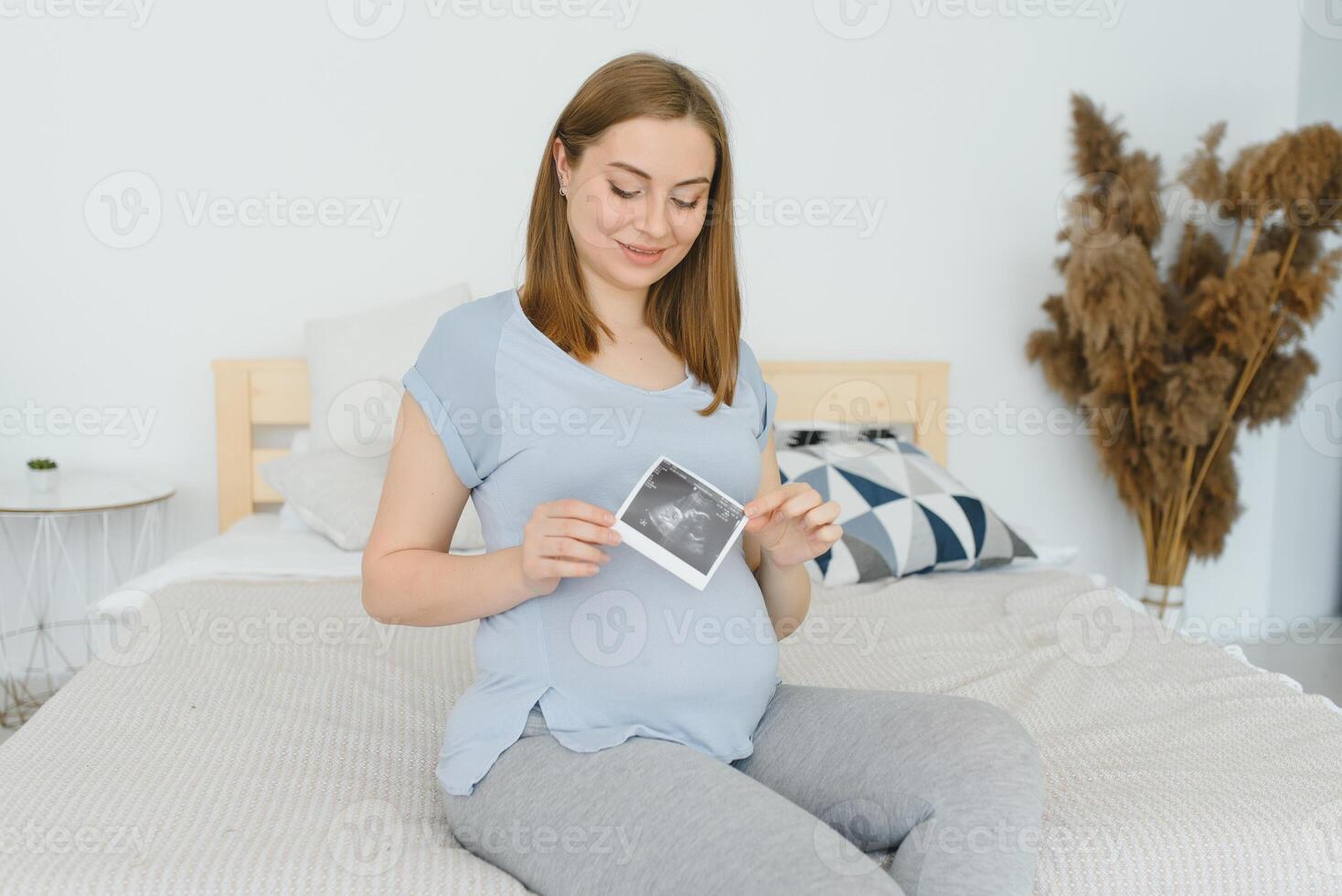 embarazada mujer mirando a su bebé ecografía. contento expectante dama disfrutando primero foto de su no nacido niño, anticipando su futuro vida, Copiar espacio