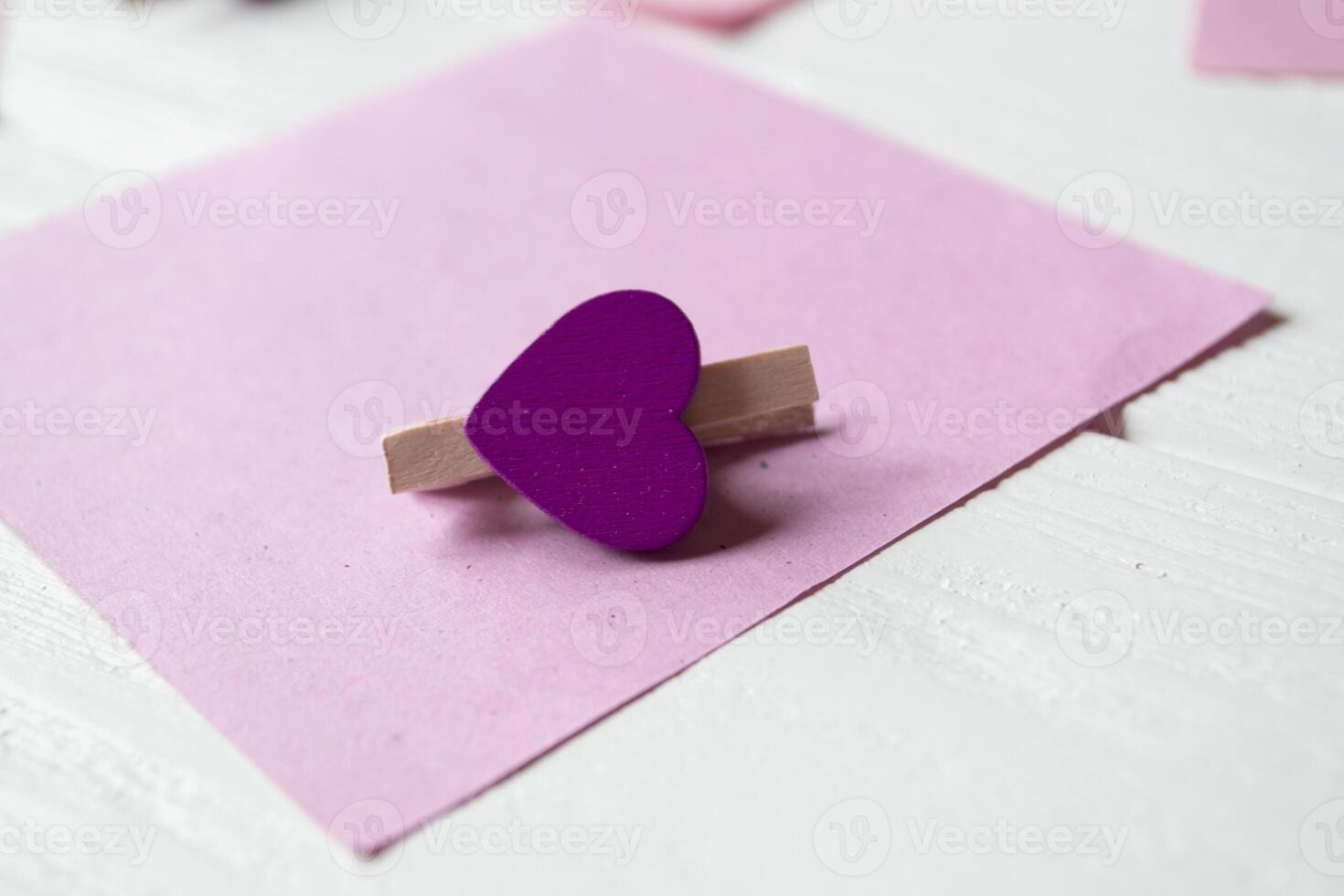 Decorative pins and pink memo sheets on a white wooden background. photo