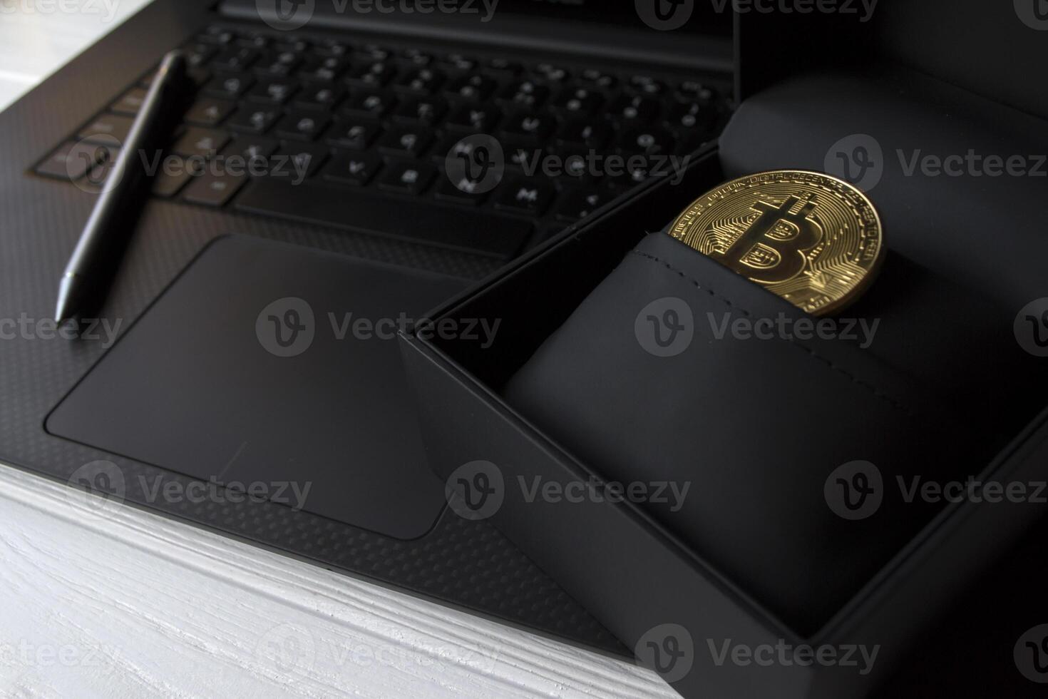 Golden bitcoin in black box on the laptop keyboard. photo