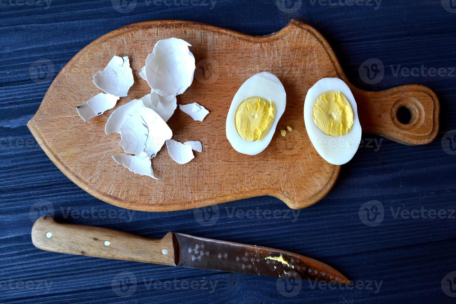 Sliced eggs, eggs shell on a wooden board. Macro food photography. Homemade food still life. photo