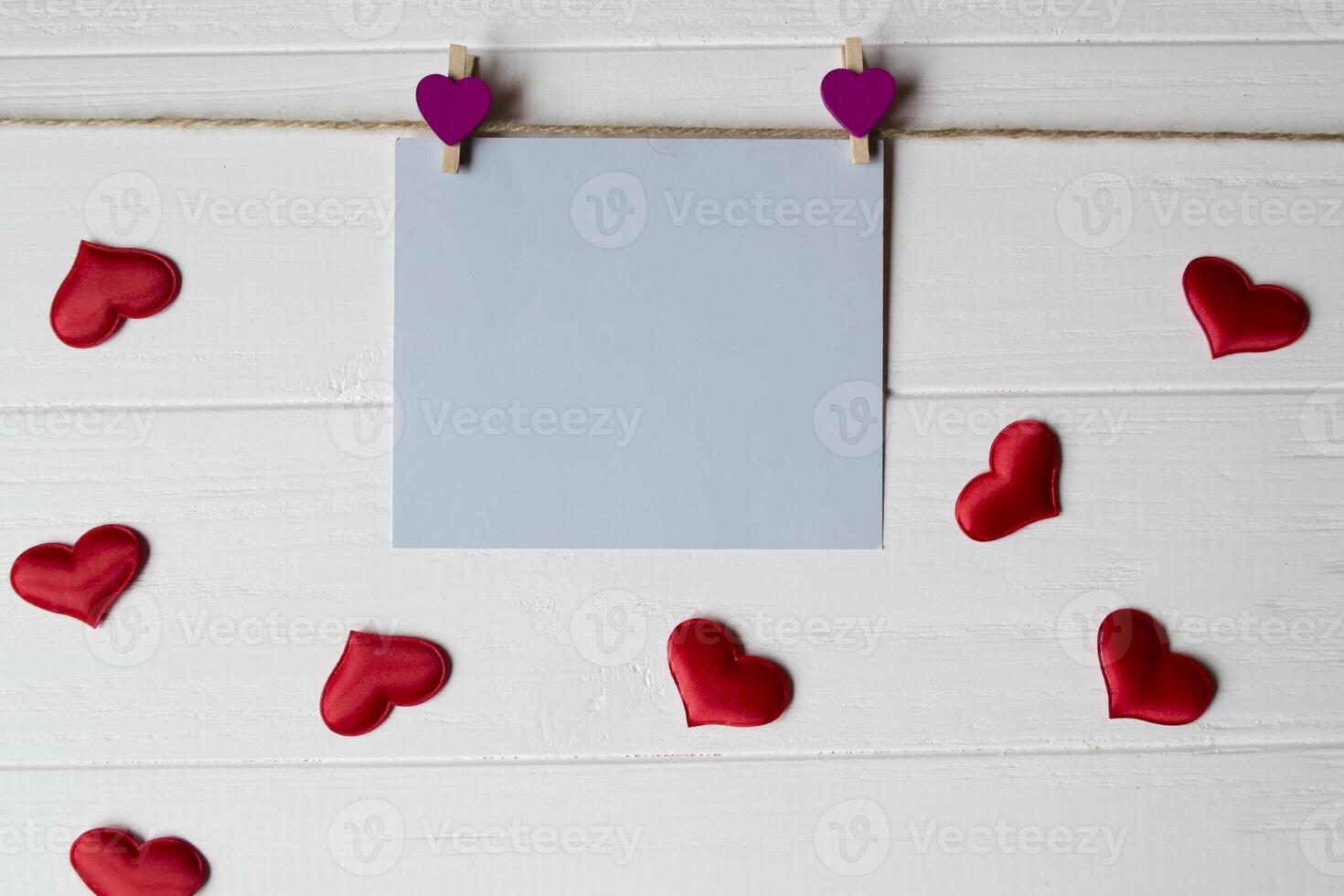 Blue memo sheet fastened with a decorative pin on a white wooden board. photo