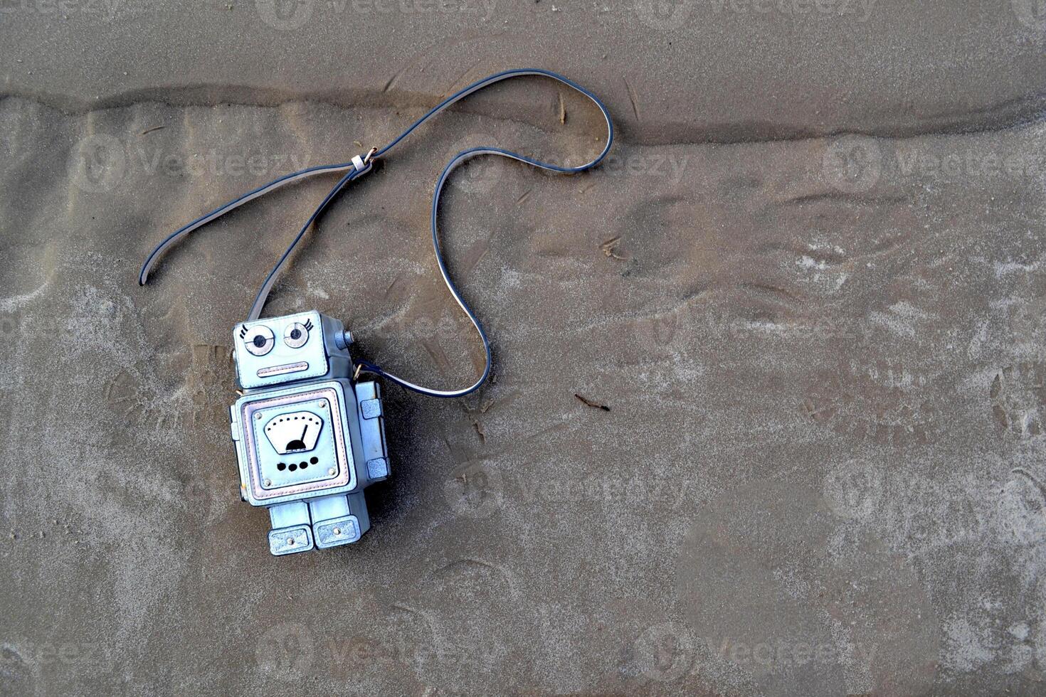 Bag in the form of a robot on the sand. photo
