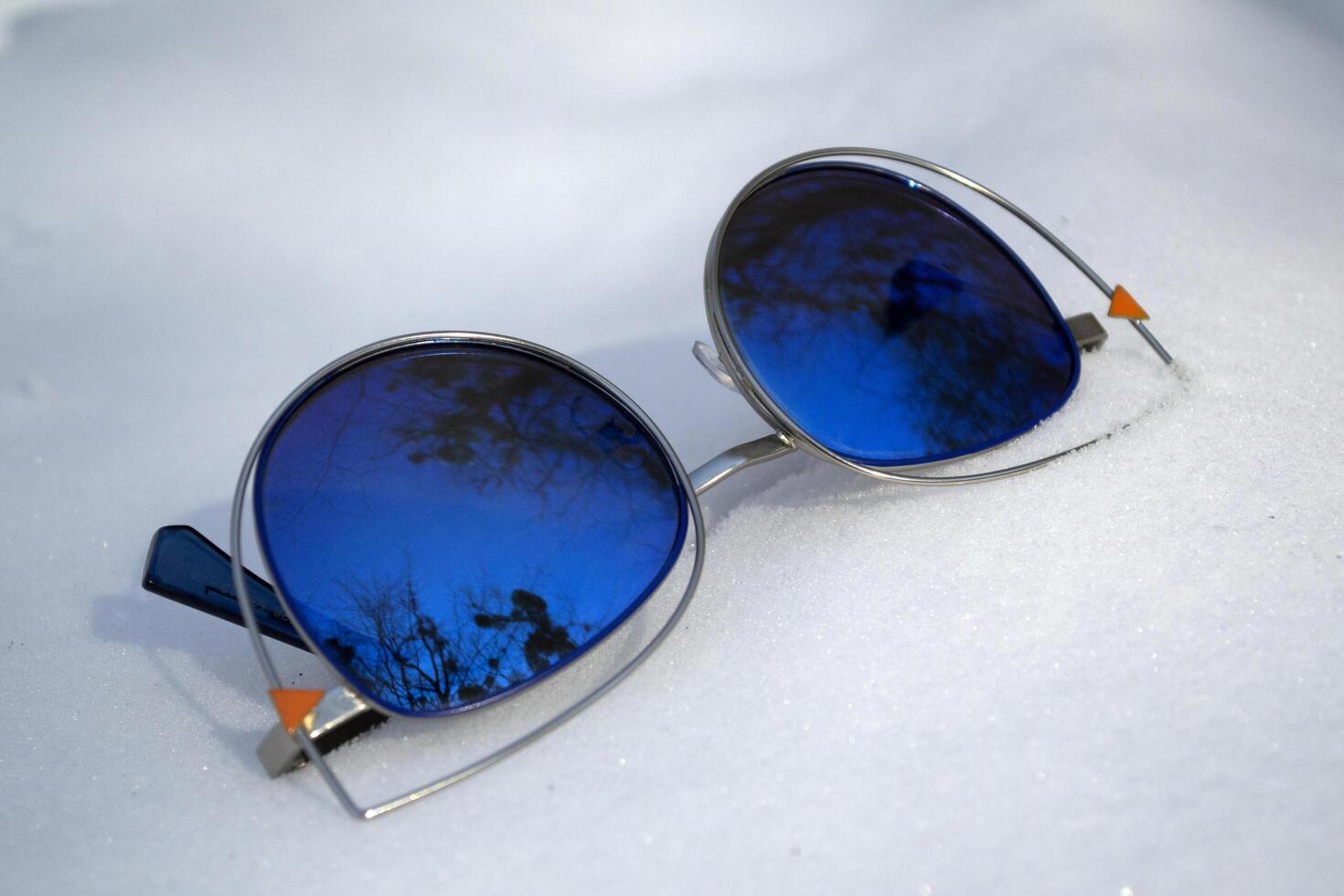 Blue sunglasses on a snow. photo
