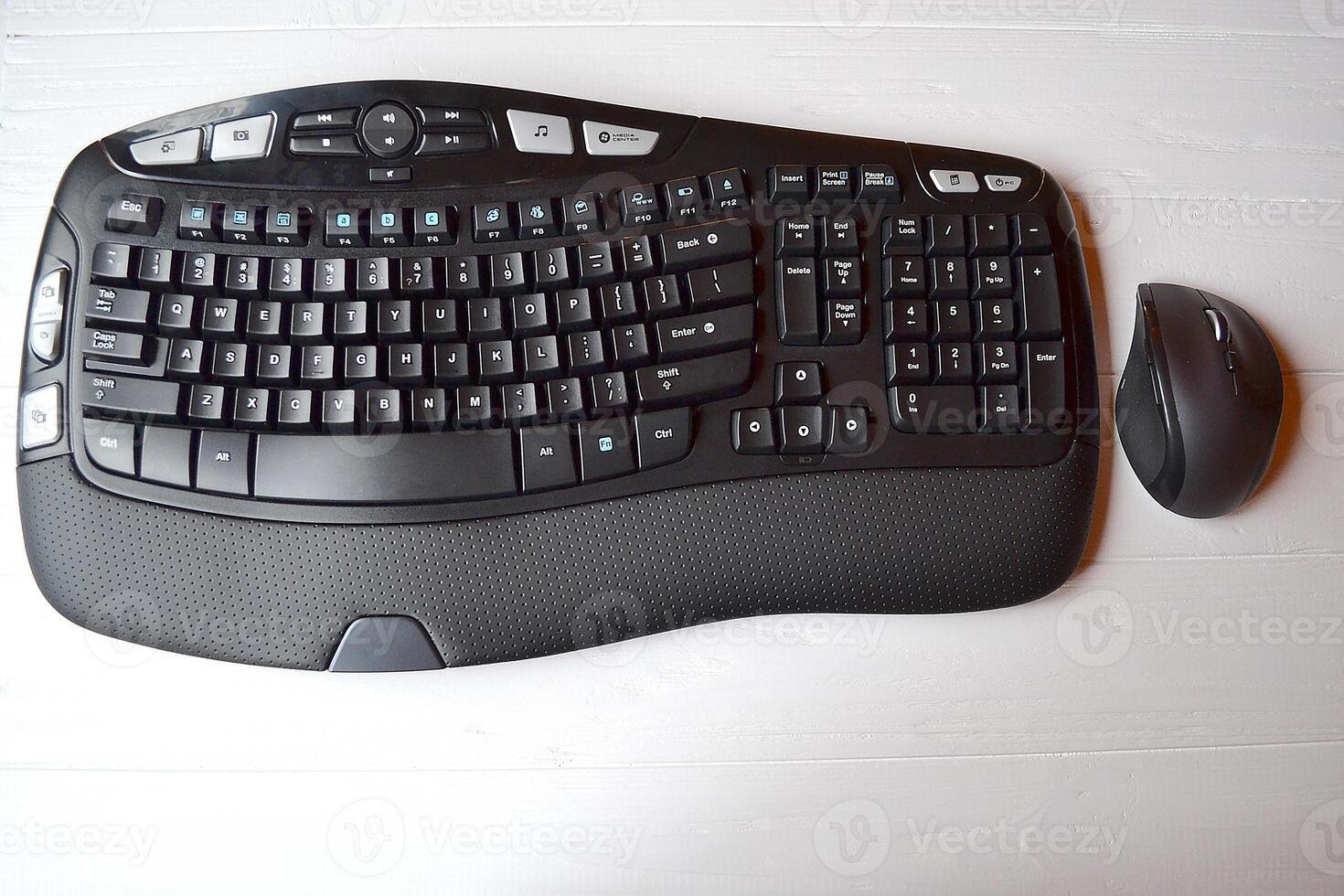 Black keyboard and mouse on the white table. photo