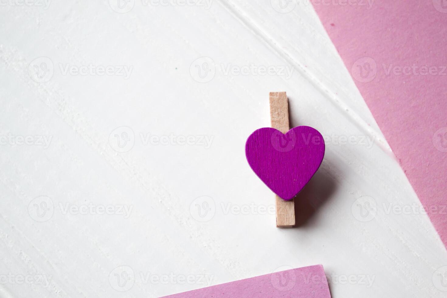 Decorative pins and pink memo sheets on a white wooden background. photo