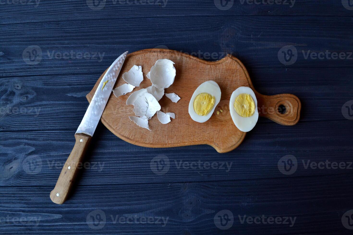 Sliced eggs, eggs shell on a wooden board. Macro food photography. Homemade food still life. photo