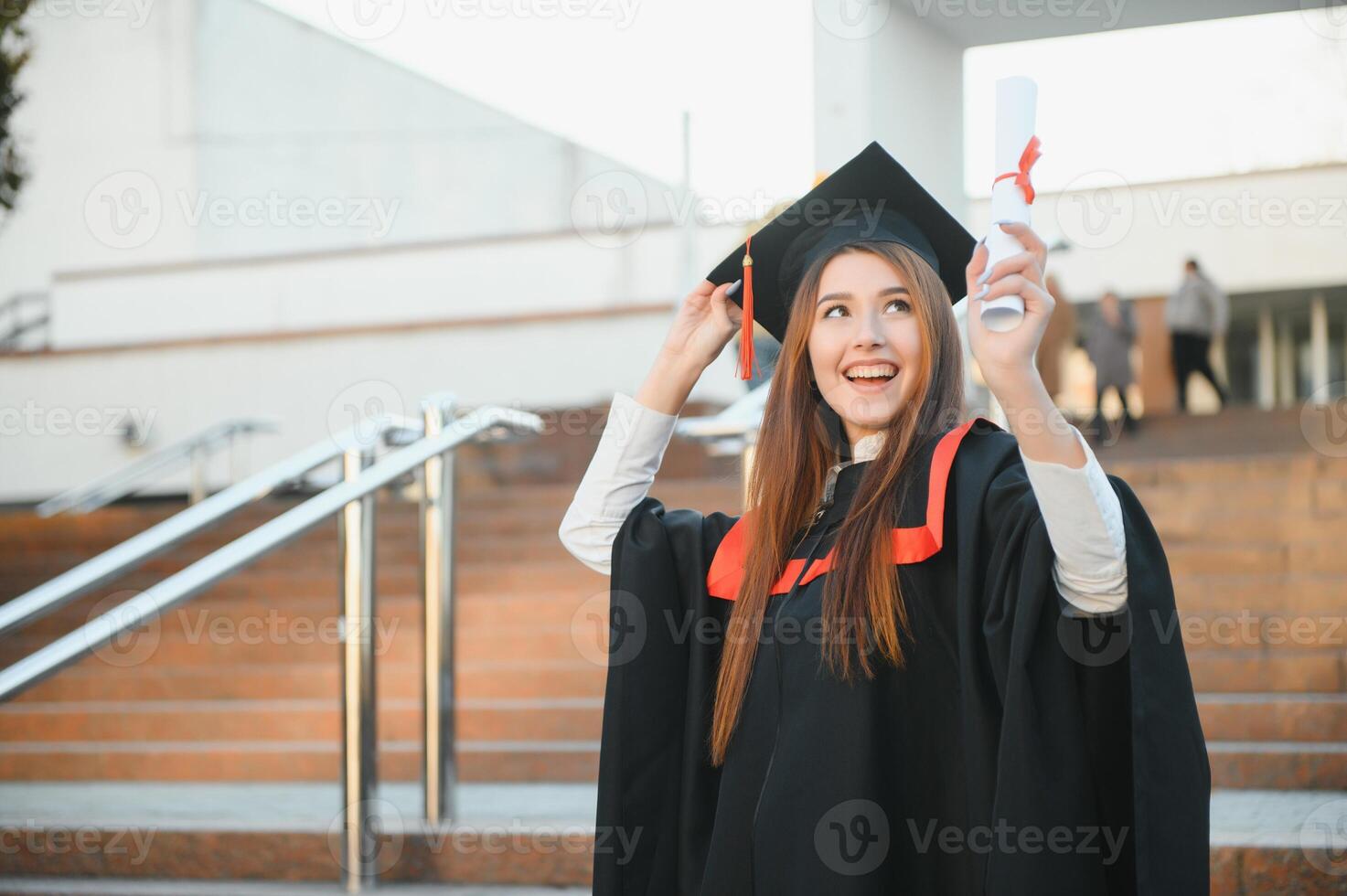 graduación estudiante en pie con diploma foto