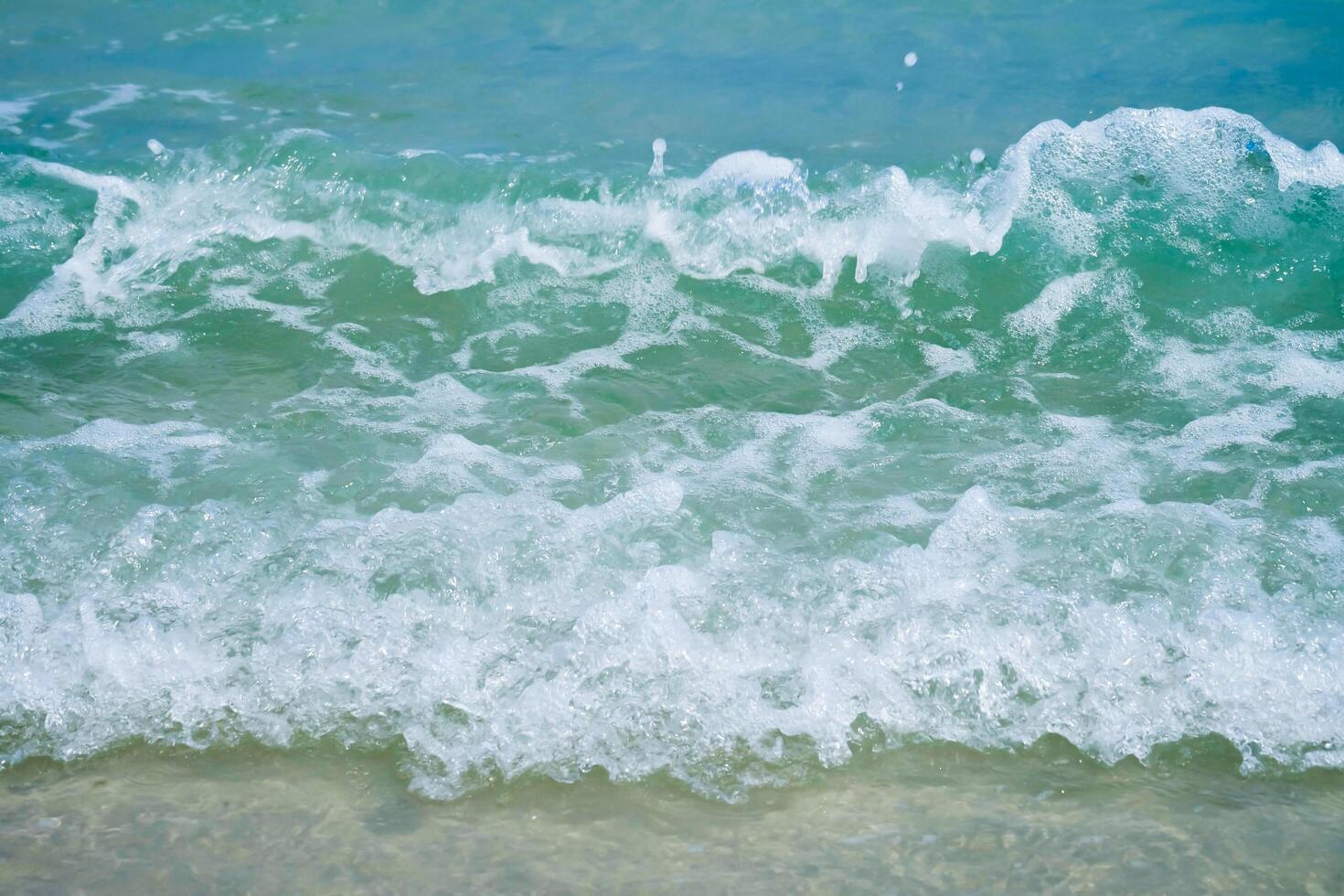 Soft wave on blue sea the tropical sandy beach as summer background photo