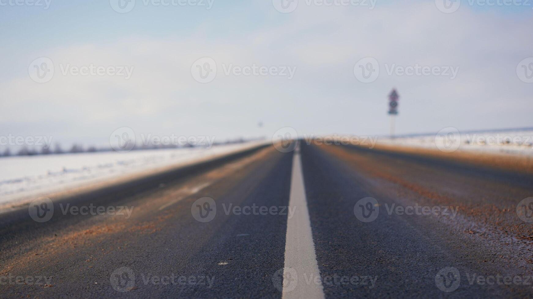 invierno antecedentes de el primer plano de el la carretera con blanco marcas asfalto en invierno. foto