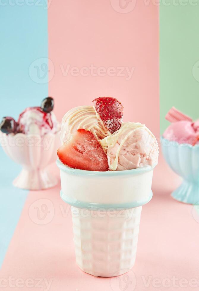 Tres hielo crema sabores en blanco y rosado tazas con cucharas en un azul, rosa, y verde antecedentes. foto