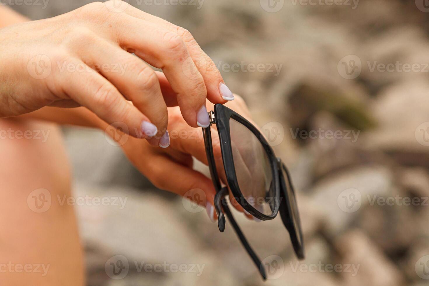 Girl in hands holding sunglasses photo
