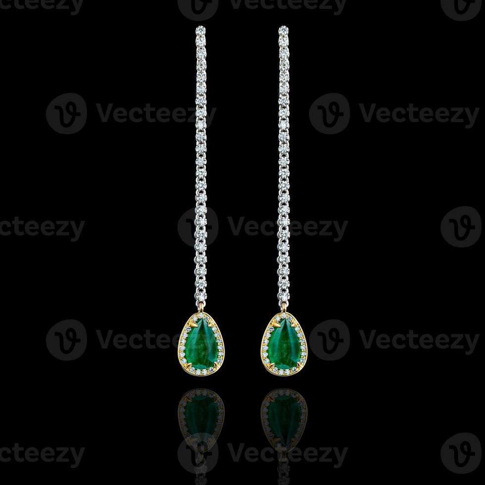 beautiful gold earrings with precious stones diamonds and emeralds on a black background photo