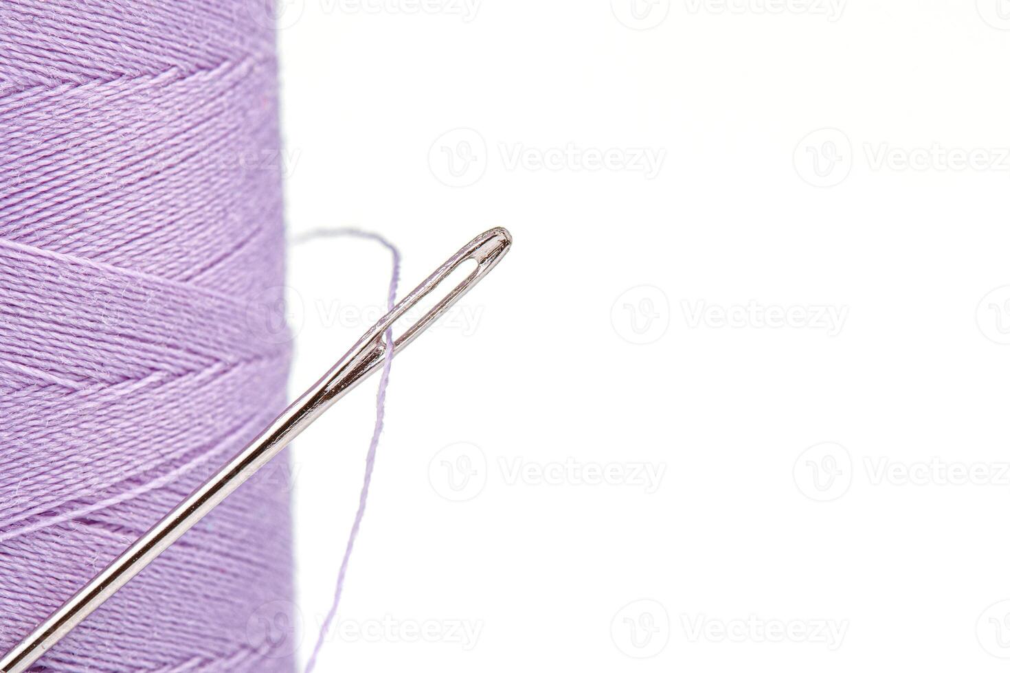 Macro skein of thread purple colors with a needle on a white background photo