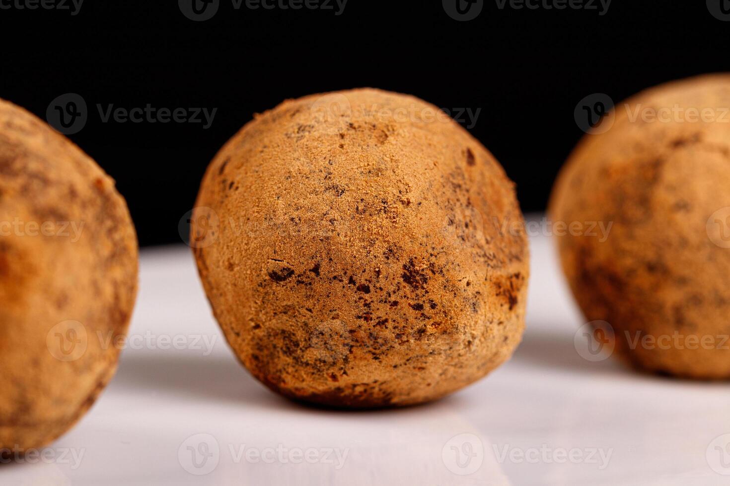 Beautiful candy truffle on a white plate on a black background photo
