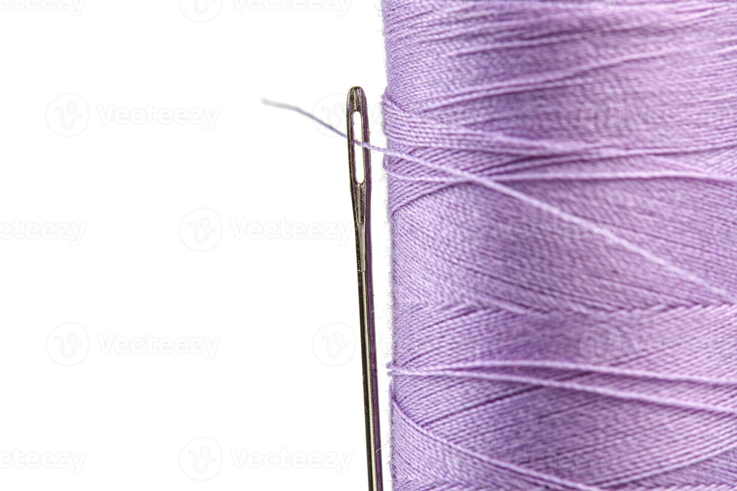 Macro skein of thread purple colors with a needle on a white background photo