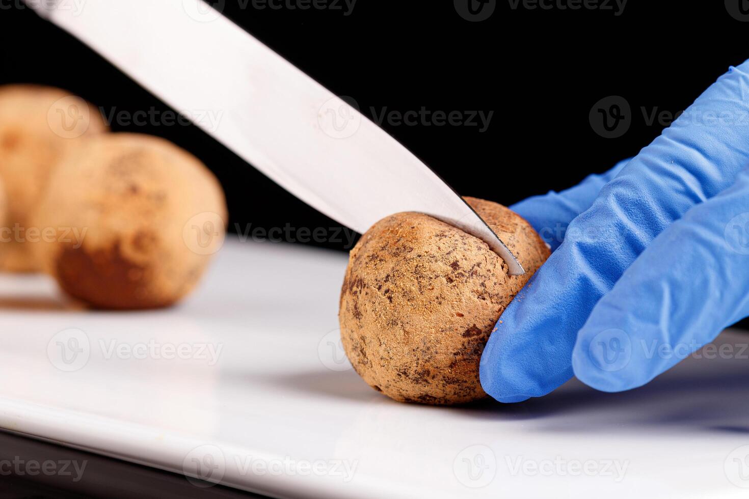 Beautiful candy truffle in a cut on a white plate on a black background photo