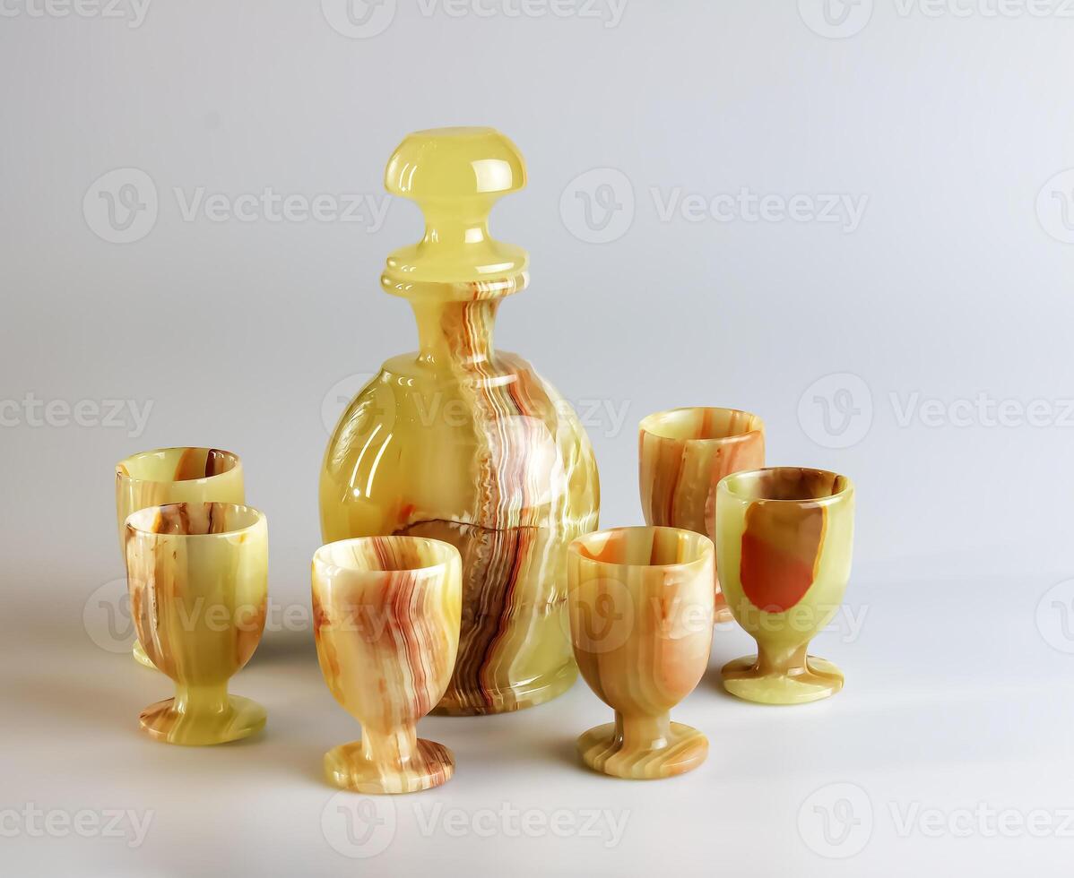 Handmade liquor container and glass made of natural onyx on a white background photo