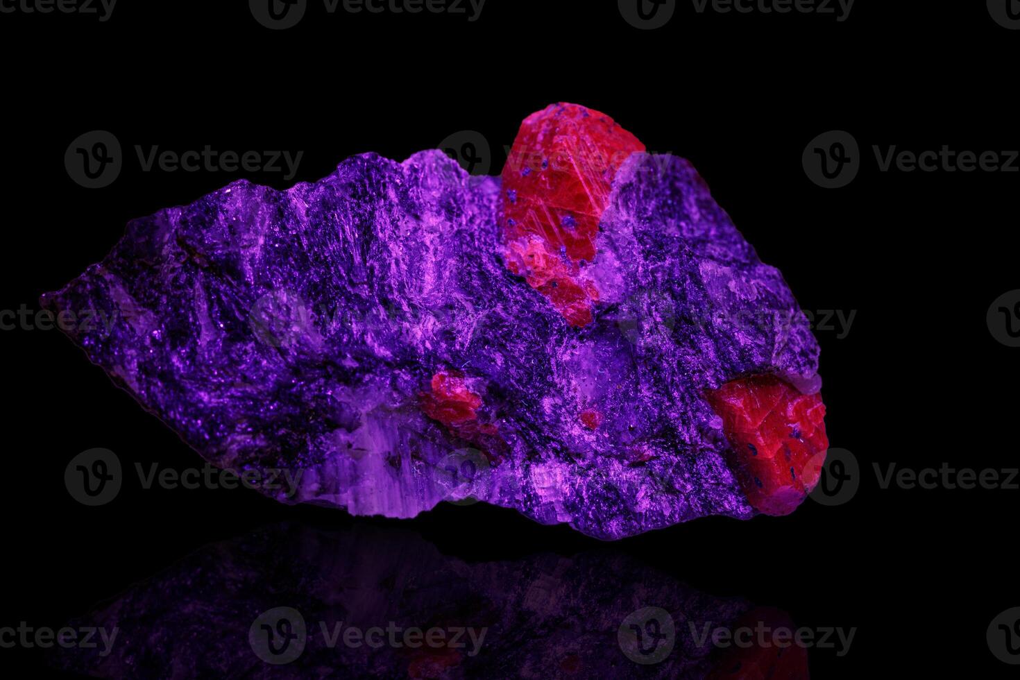 macro mineral stone ruby under ultraviolet light on a black background photo