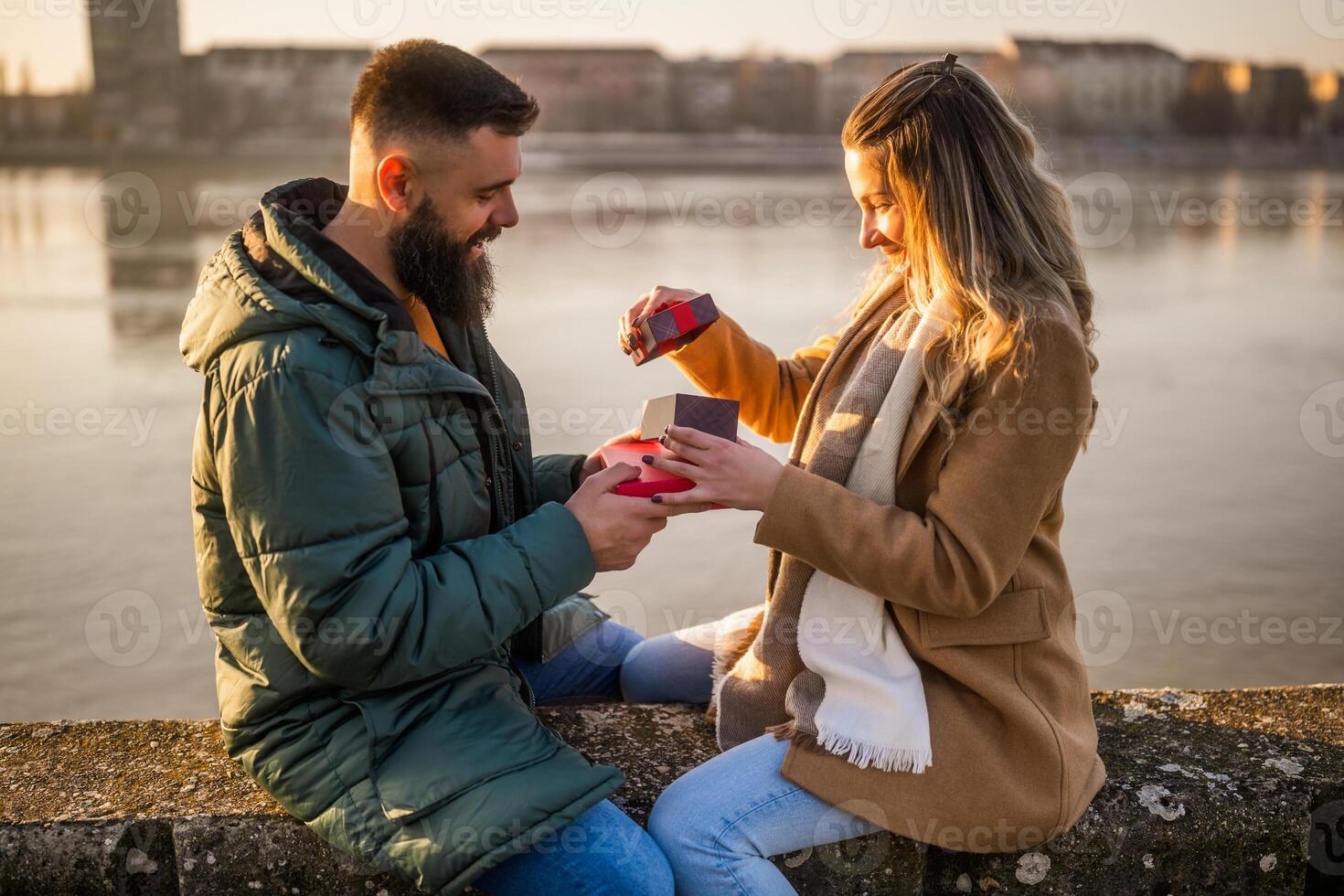 Man giving presents to his woman while they enjoy spending time together outdoor. photo