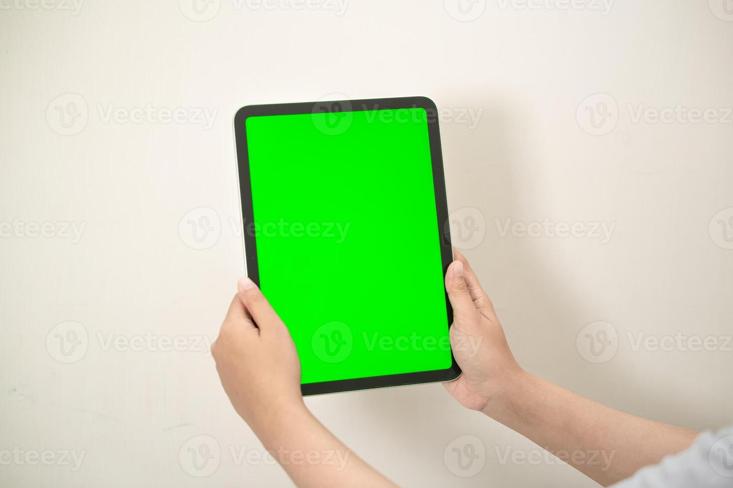 hand is holding a tab with green screen on a white isolated background photo