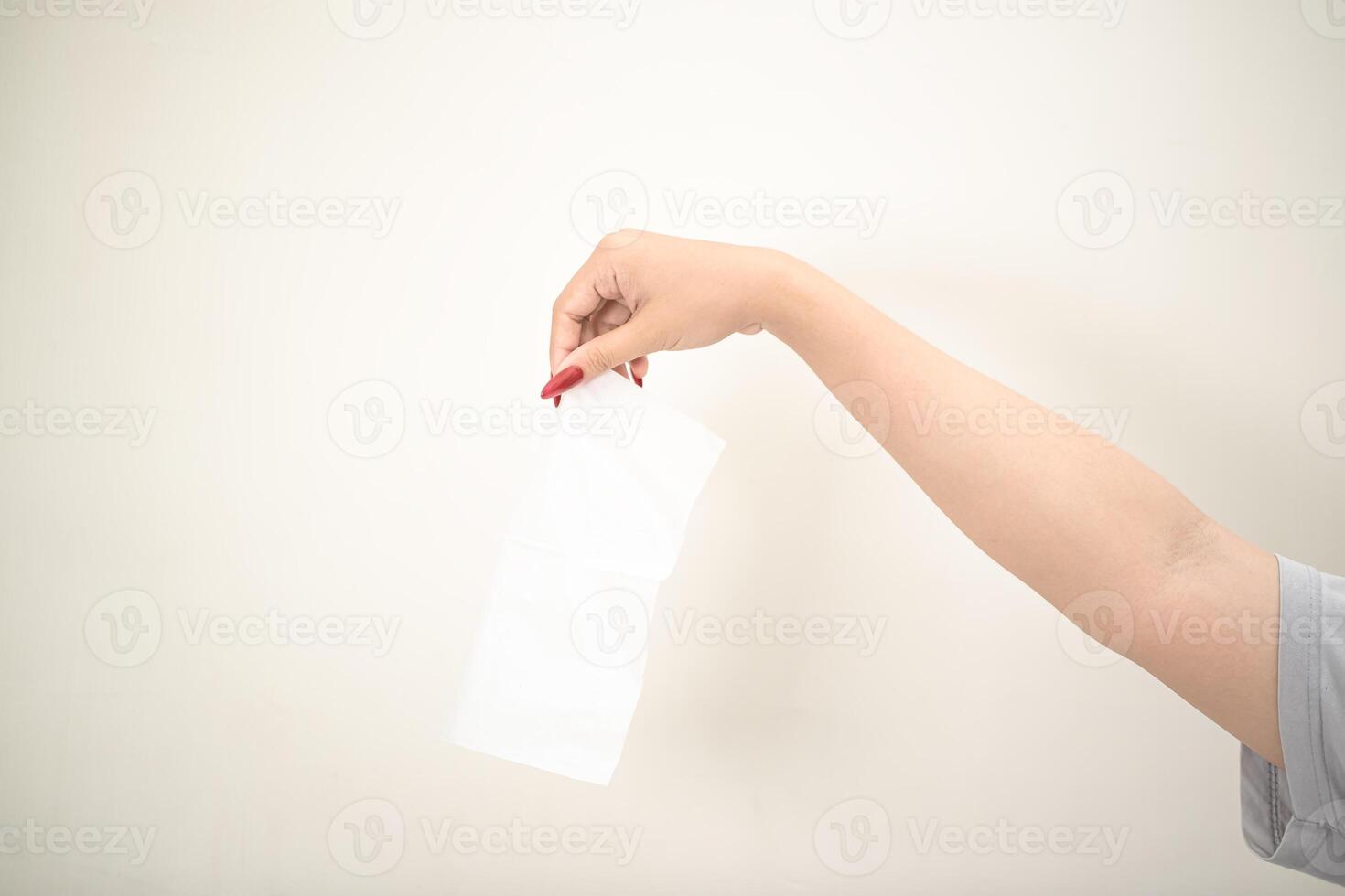 hand is holding a piece of tissue on a white isolated background photo