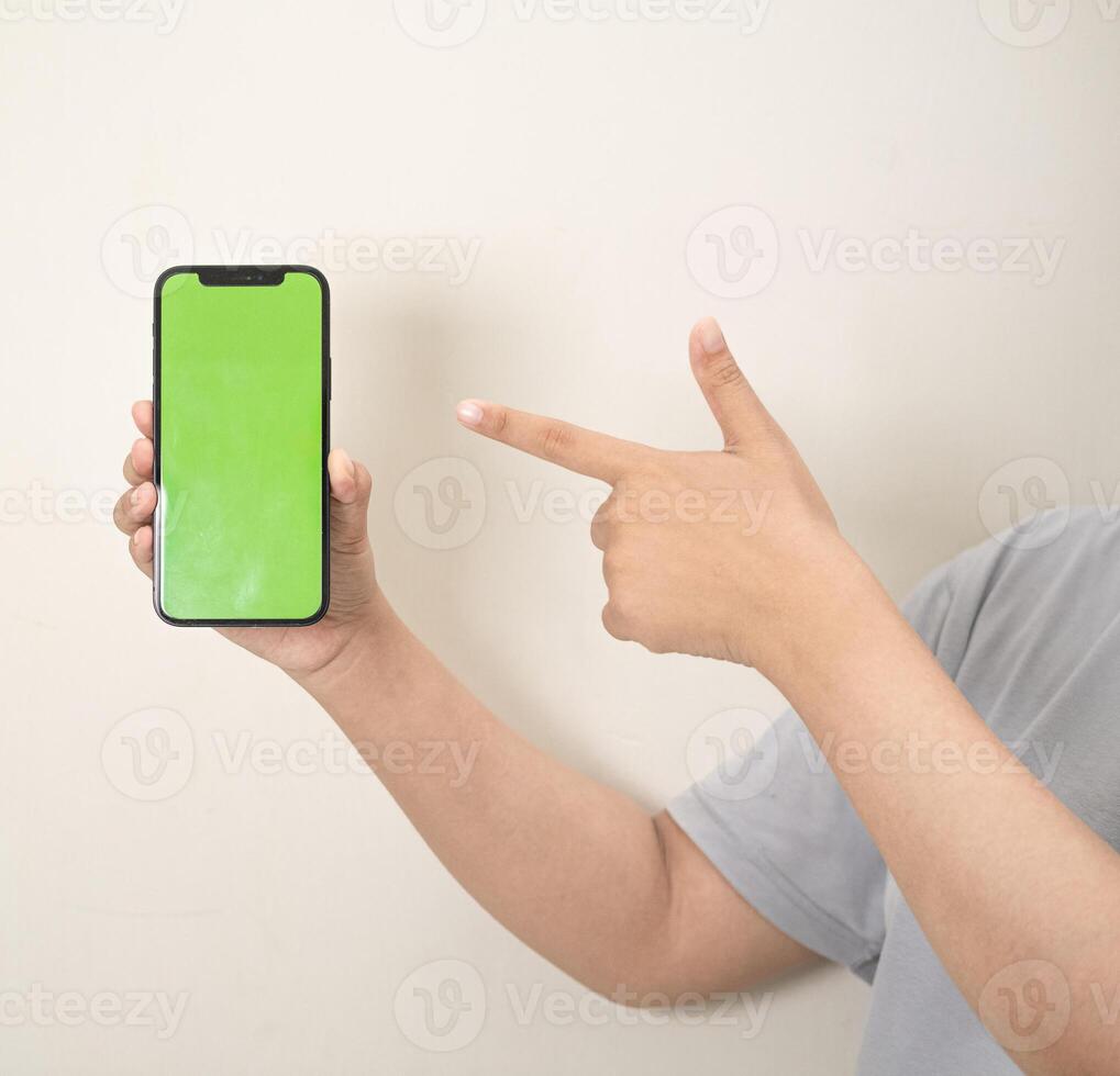 hand is holding a phone with green screen on a white isolated background photo