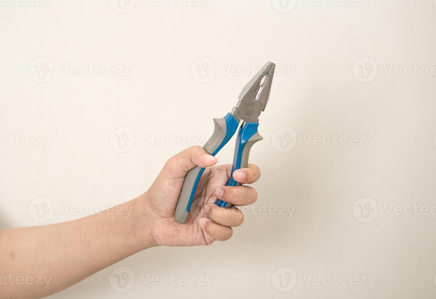 hand is holding a pliers on a white isolated background photo