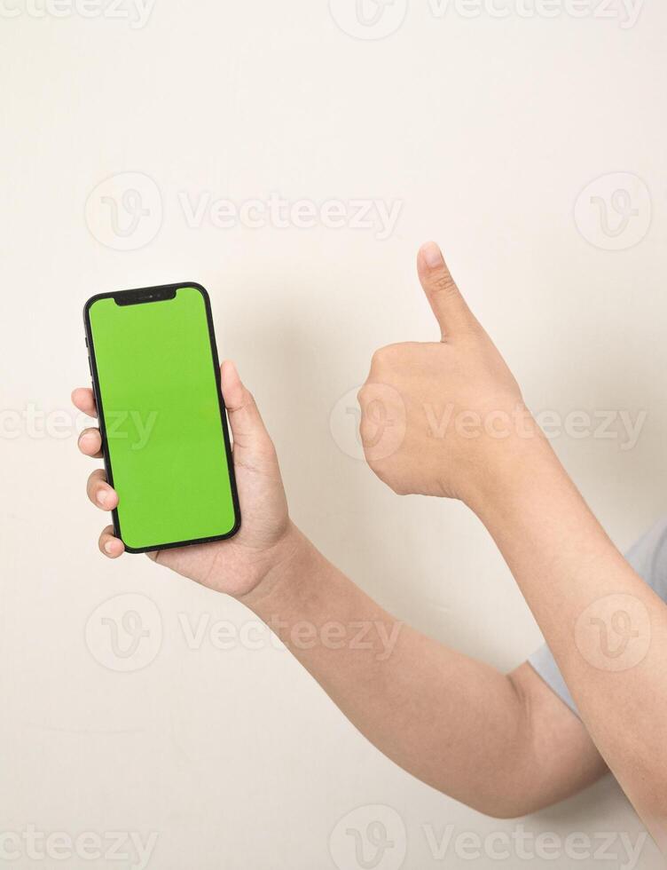 hand is holding a phone with green screen on a white isolated background photo