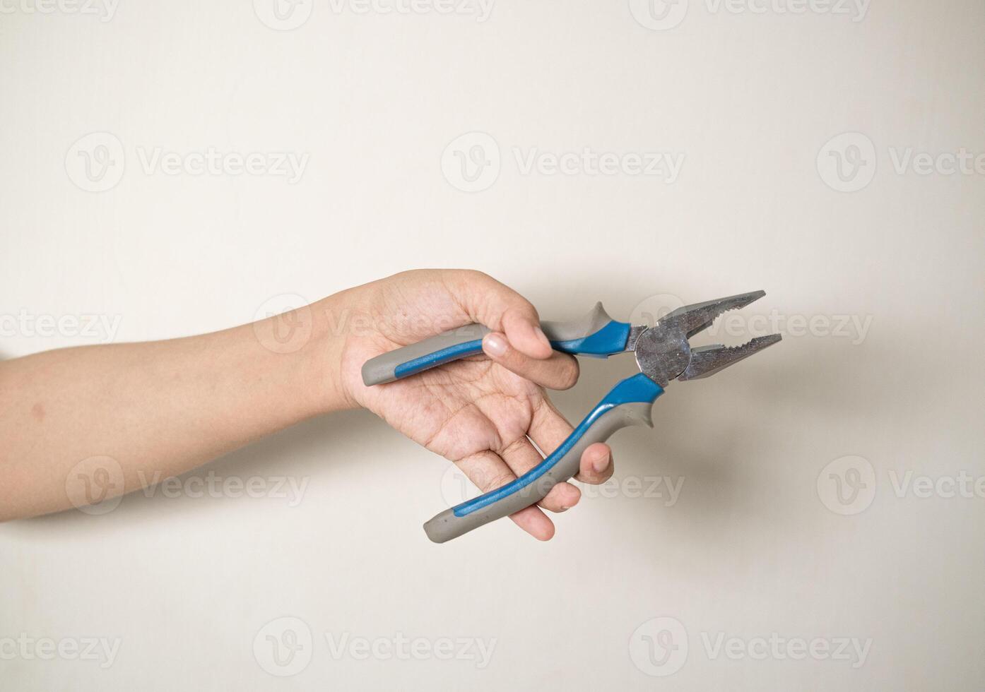 hand is holding a pliers on a white isolated background photo