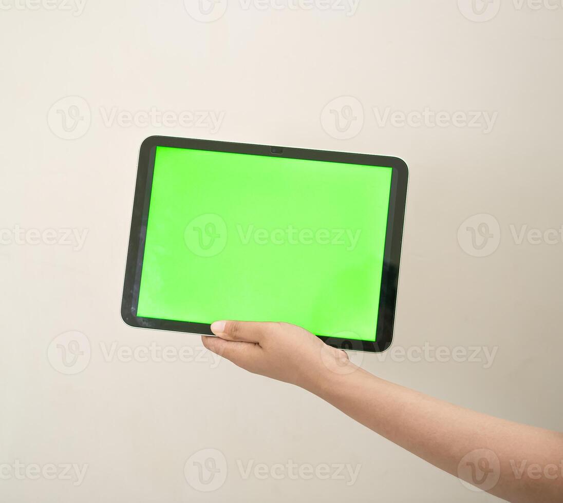 hand is holding a tab with green screen on a white isolated background photo