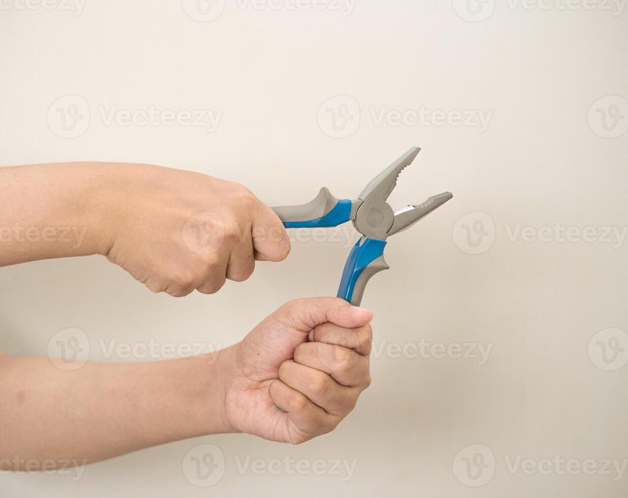 hand is holding a pliers on a white isolated background photo