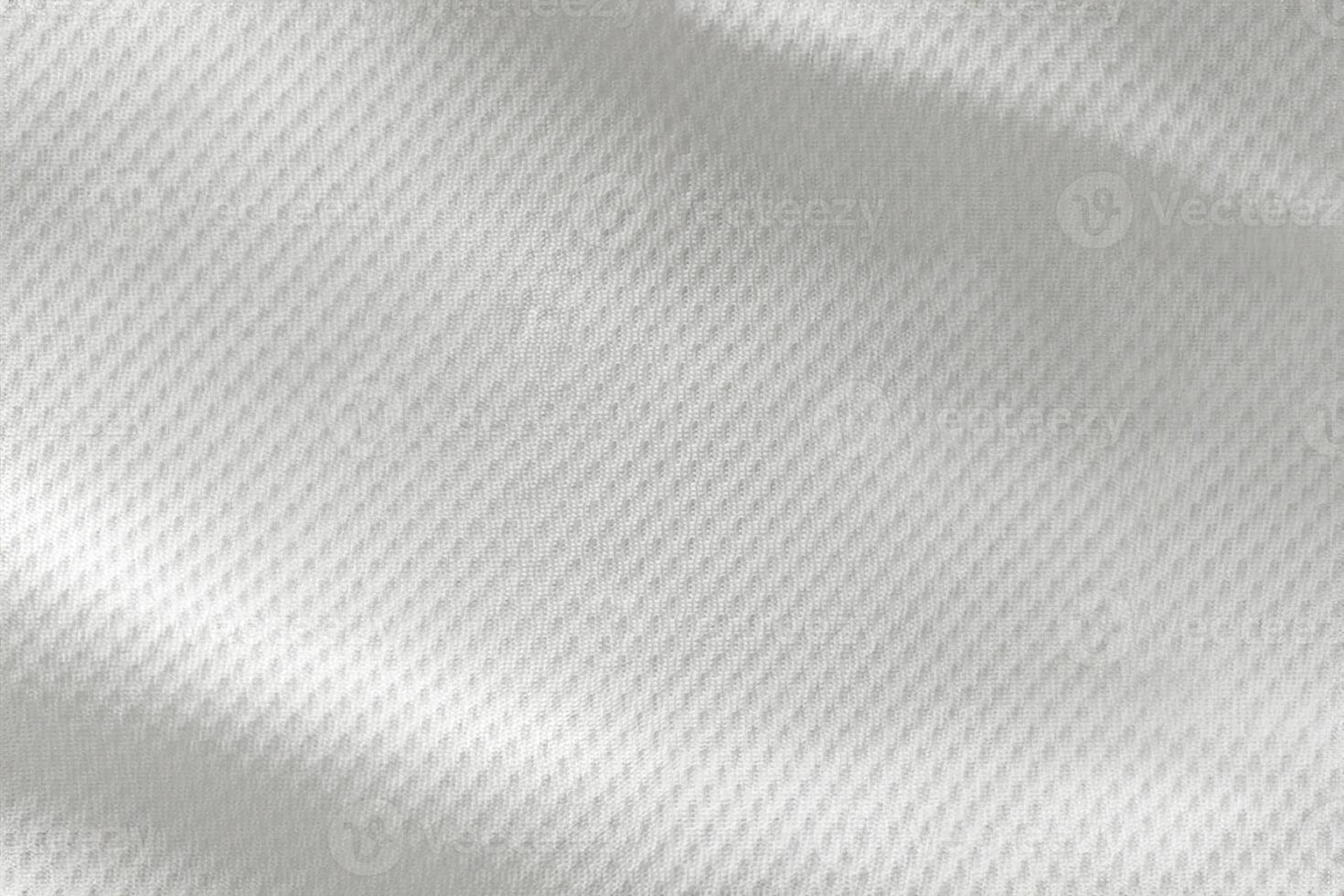 A close-up top view of the texture of a white sports fabric jersey football shirt. photo