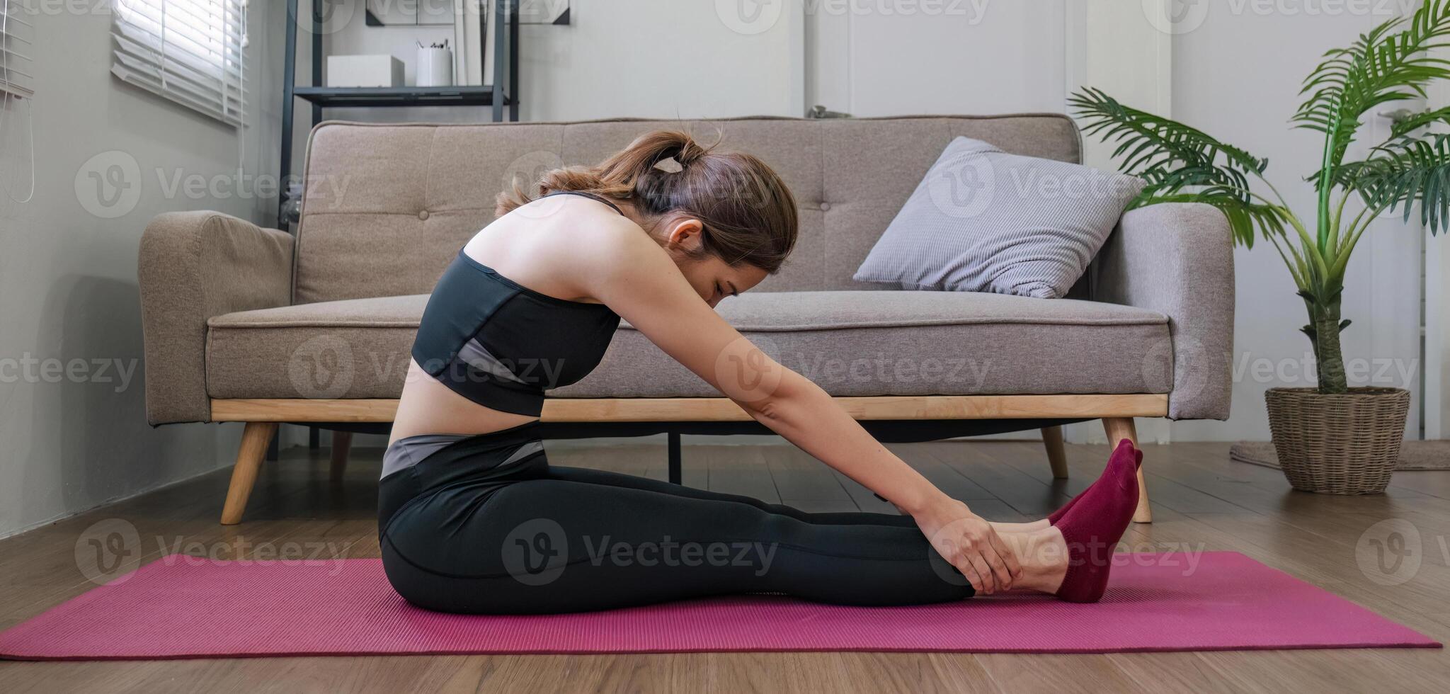 Young Asian woman practicing yoga at home in various poses sitting on the living room floor The concept of rest, relaxation, exercise. photo