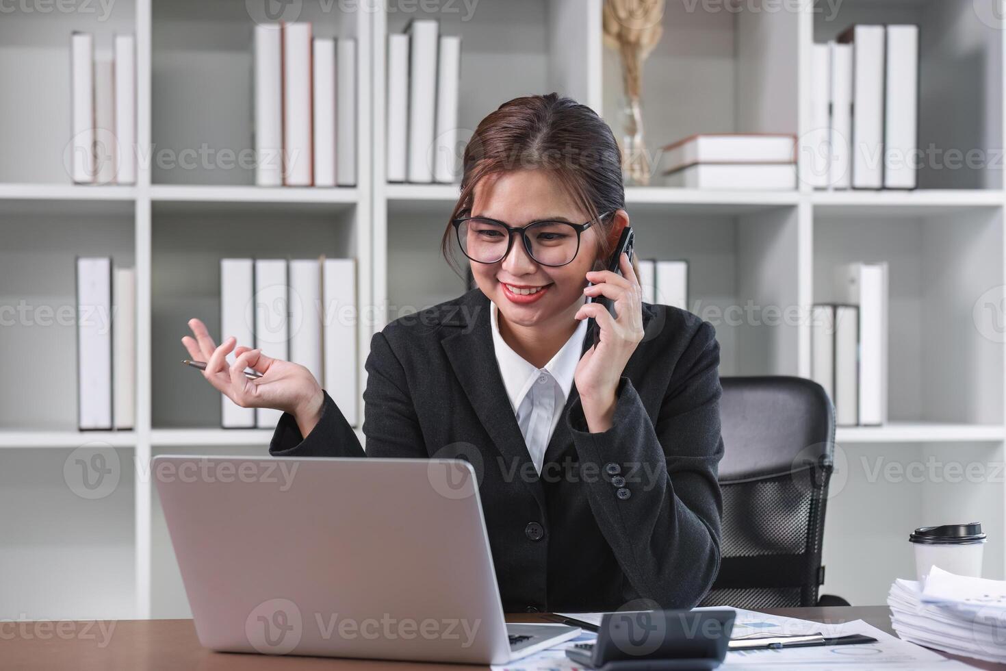 Young Asian woman using laptop to do financial transaction and plan finances and investments through online banking photo