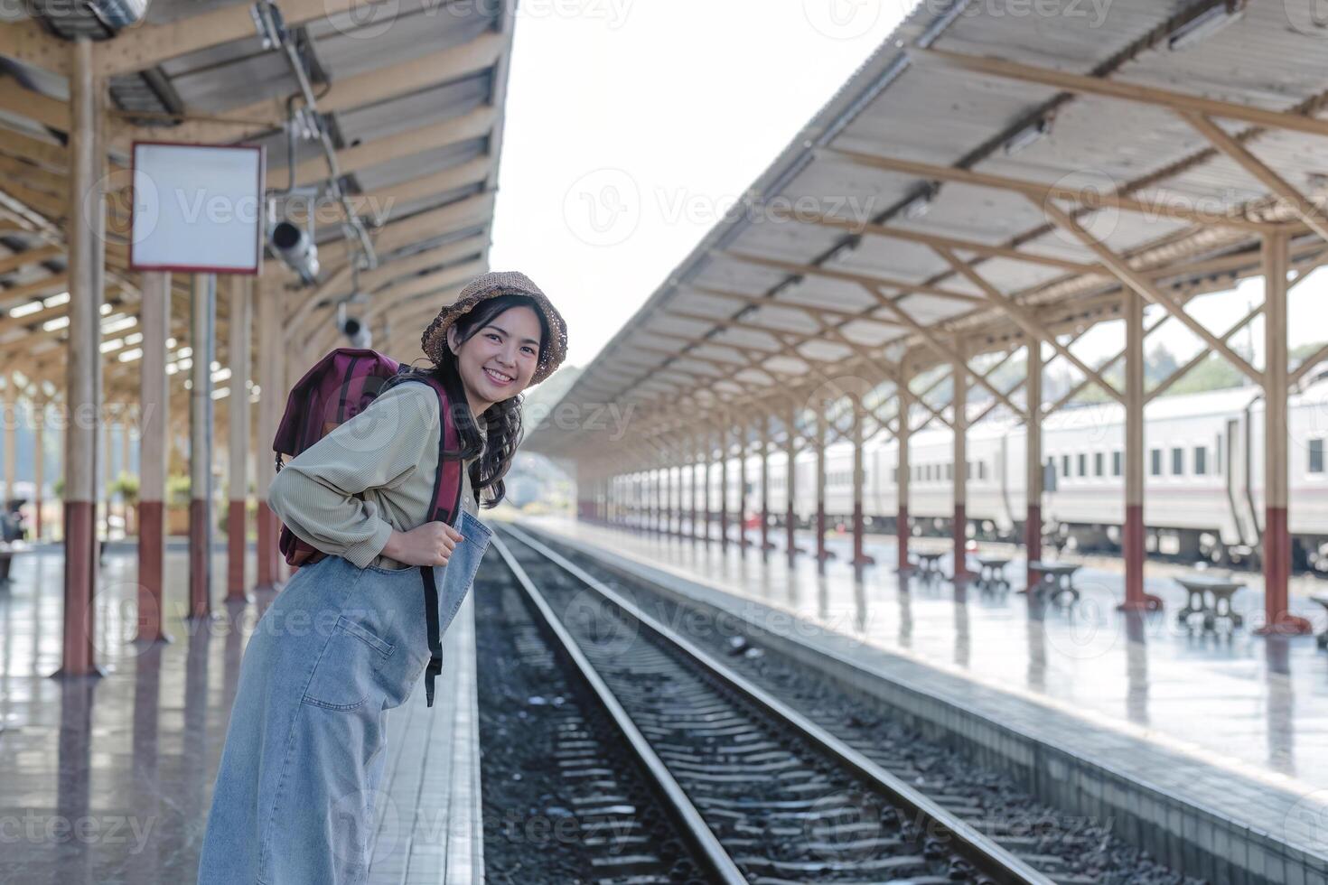Young Asian woman in modern train station Female backpacker passenger waiting for train at train station to go on holiday. photo