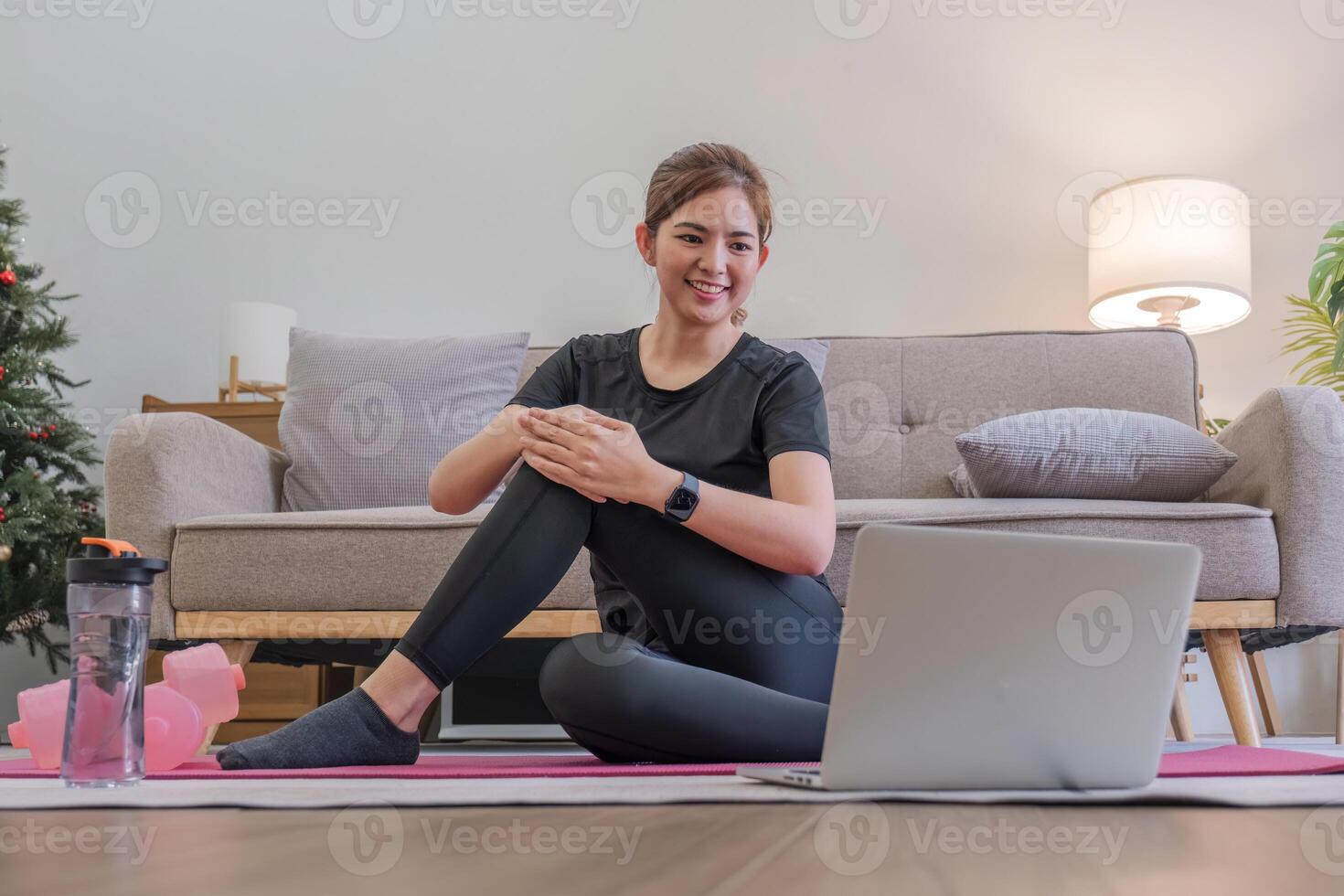Young Asian sporty fitness woman coach do practice video online training yoga laptop in living room at home photo