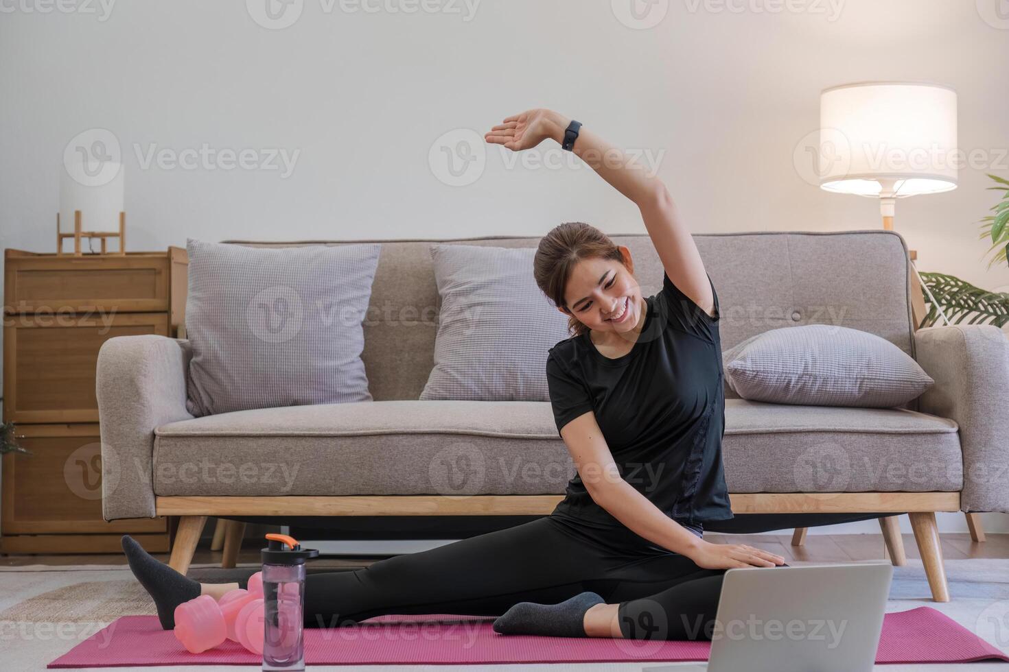 Young Asian sporty fitness woman coach do practice video online training yoga laptop in living room at home photo