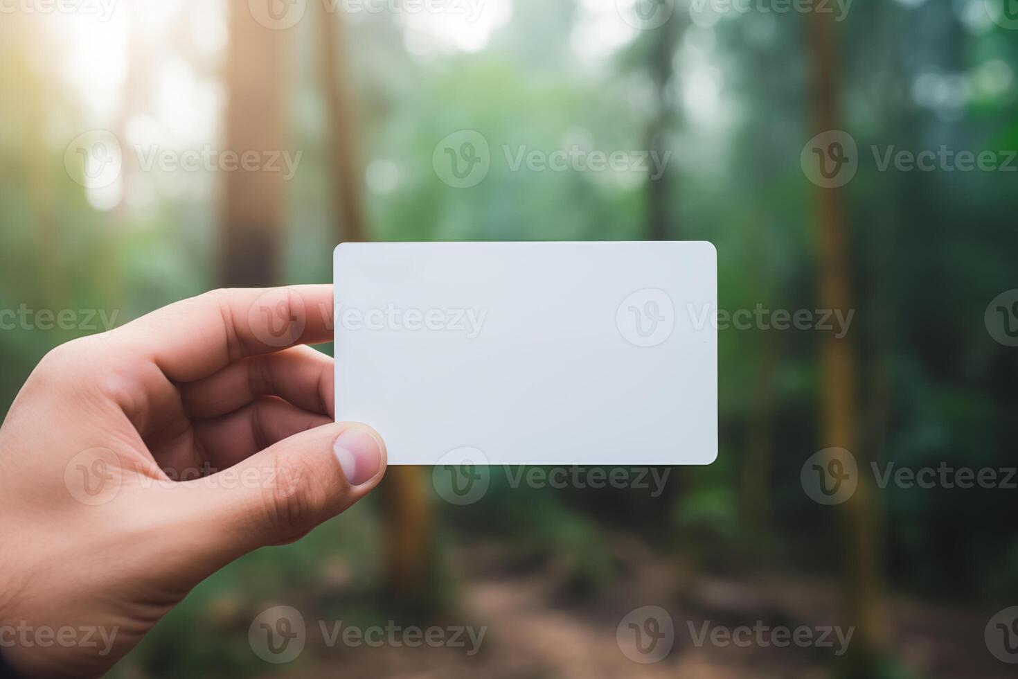 AI generated Hand holding blank white business card mockup on blurred nature background photo