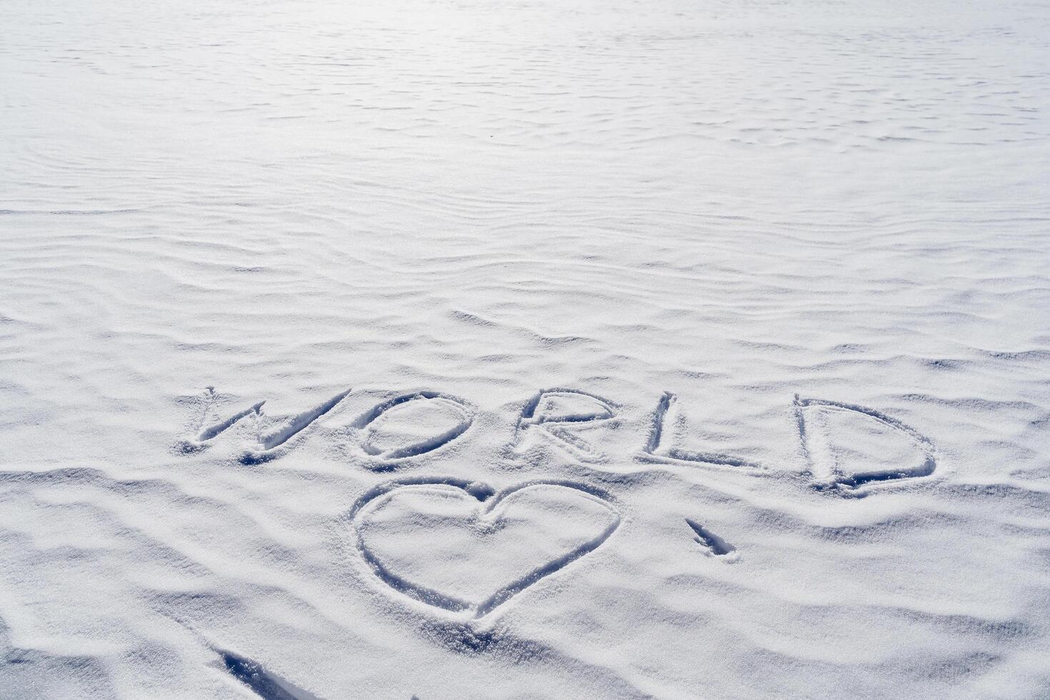 The heart is painted in the snow, the inscription peace was written on a white background of frozen ice. The concept of world reconciliation of the love of mankind. photo