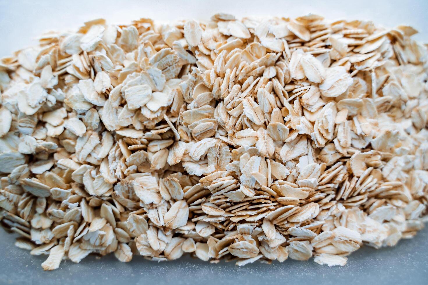 Rolled oats. Dry oatmeal grains. A bunch of white fresh seeds. photo