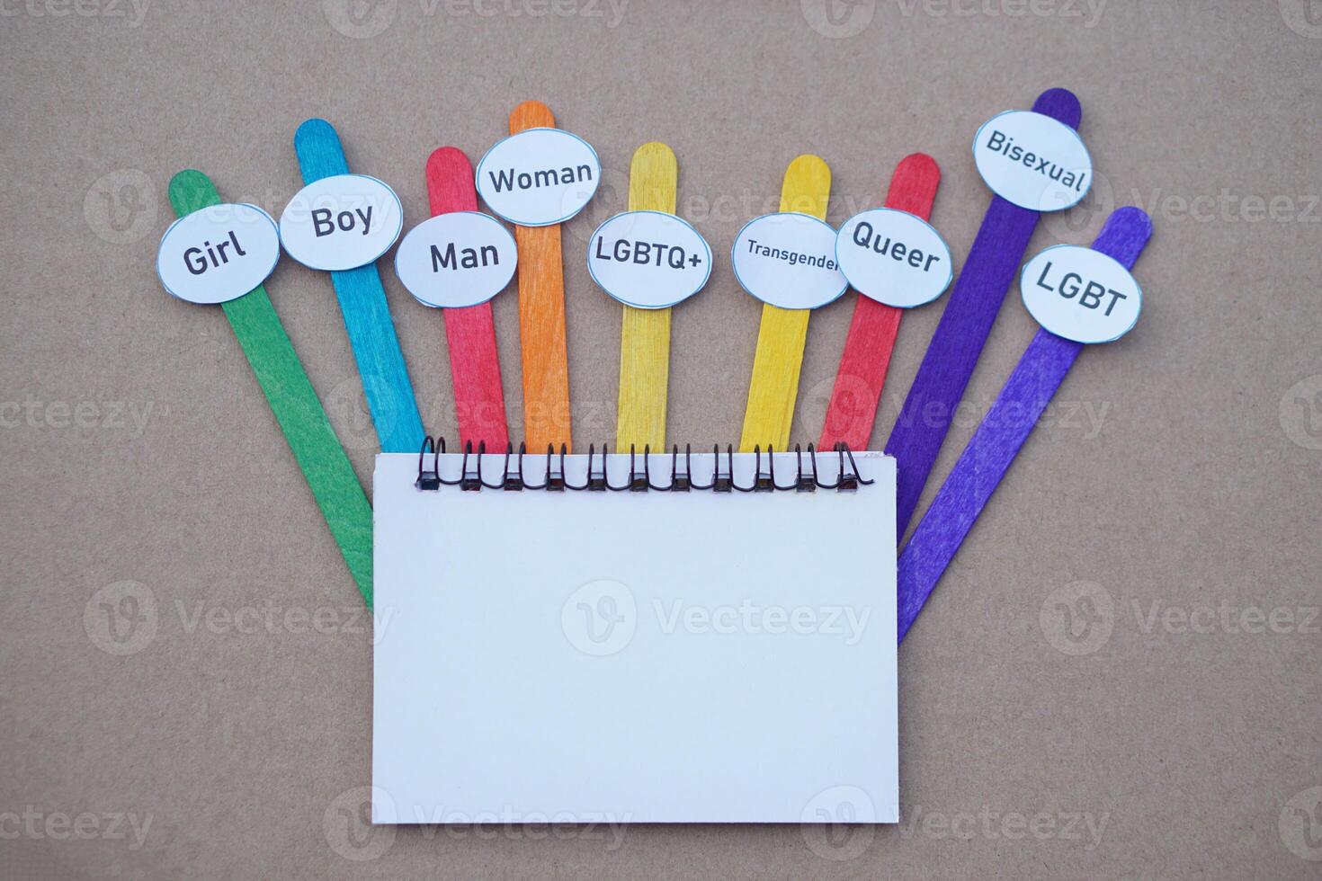 DIY colorful sticks with paper words about diversity genders, blank paper. Brown background. Concept, Educational teaching materials. Vocabulary, language learning lesson. photo