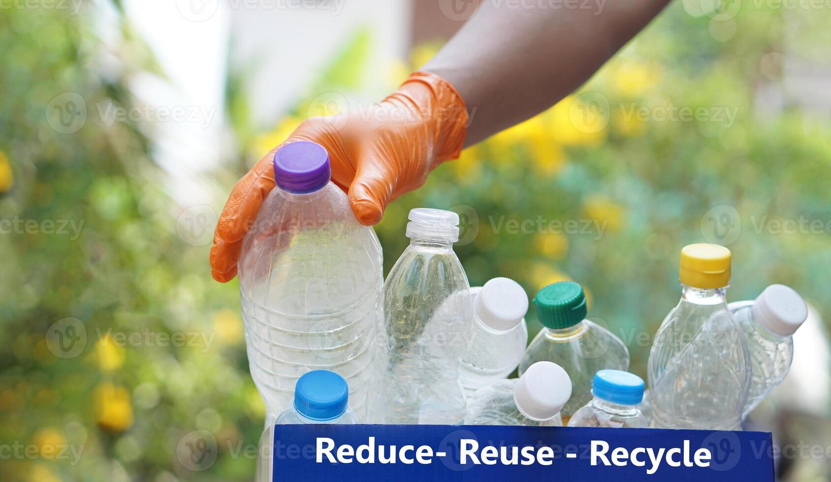 Hand holds used plastic bottle to put in junk bin for recycling. Concept, sorting garbage campaign before throw away for reuse or recycle. Environment conservation. Eco friendly activity. photo