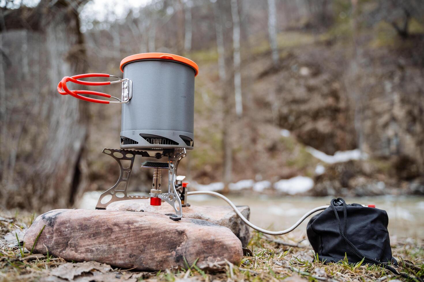 Tourist dishes, a pot stands on a gas burner, a hike to cook food on gas, ultra-light equipment for a tourist, spring trekking in the forest through the mountains. photo