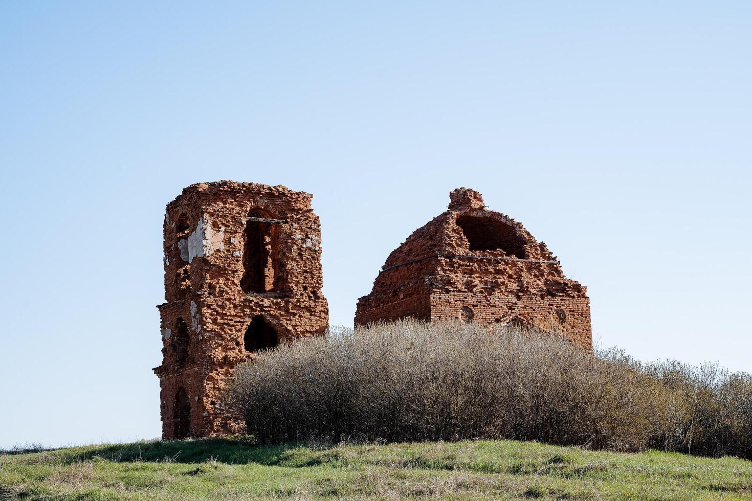 An ancient ruined temple, the ruins of an Orthodox church, a Christian temple is abandoned in a field, the roof of the building, the bell tower are broken. photo