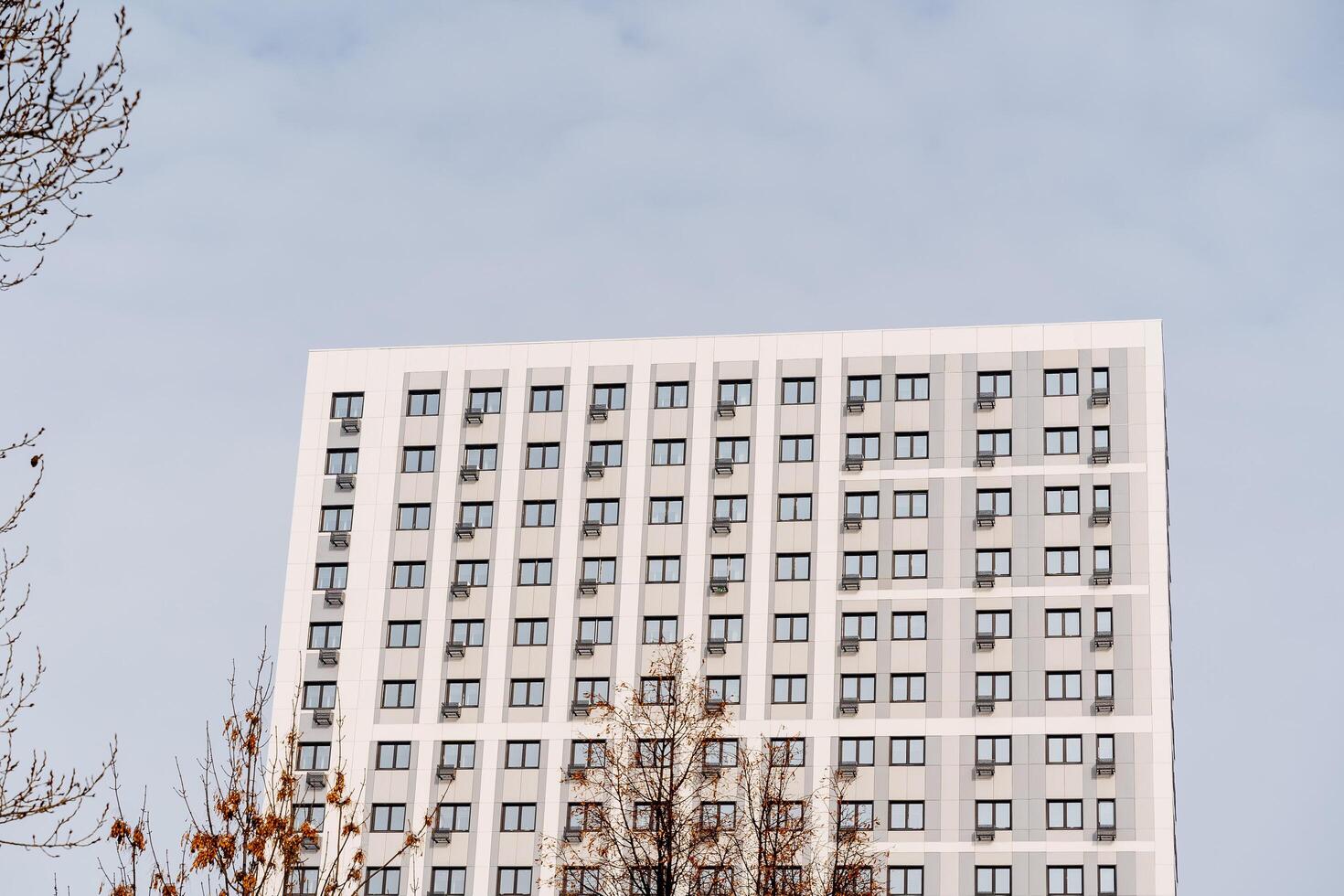 Breathtaking view from afar of a multi-storey white building. Residential complex for comfortable housing.apartment rising high up to the sky photo
