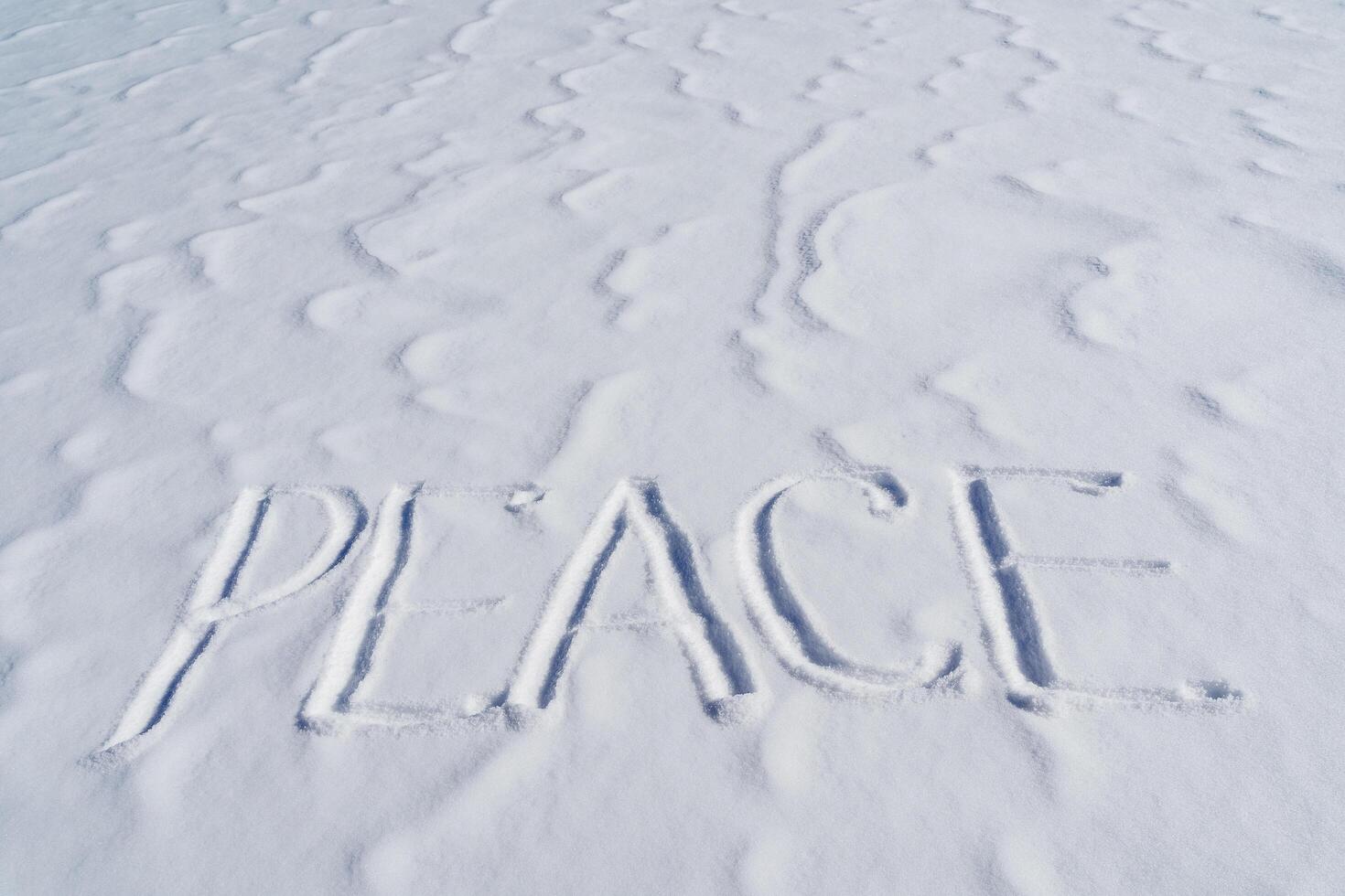 The word peace is written in the snow. Letters calling for the unification of countries around the world. The concept of peaceful coexistence of the population. Text to write in the snow. photo