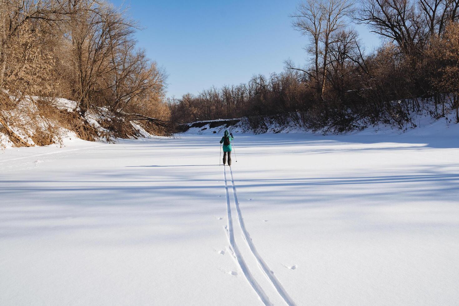 Ski run on snow, skier runs on white snow in nature. Sports lifestyle, outdoor recreation in winter in the cold season. photo