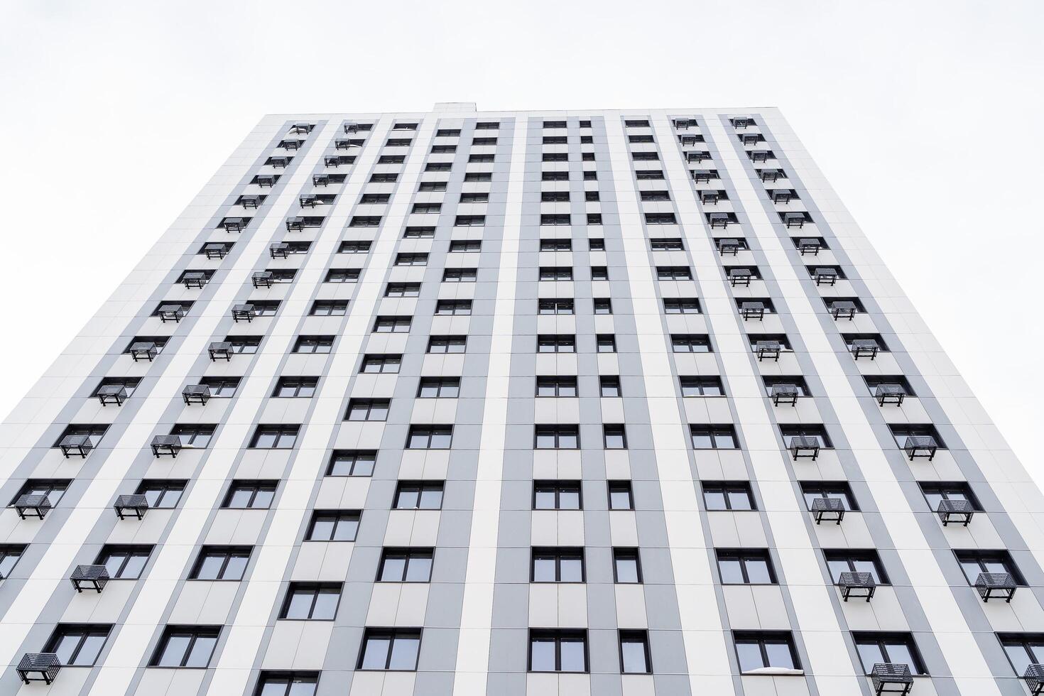 Modern residential complex with many apartments. The building rises high into the sky. Perspective and strict lines. Facade of an apartment building photo