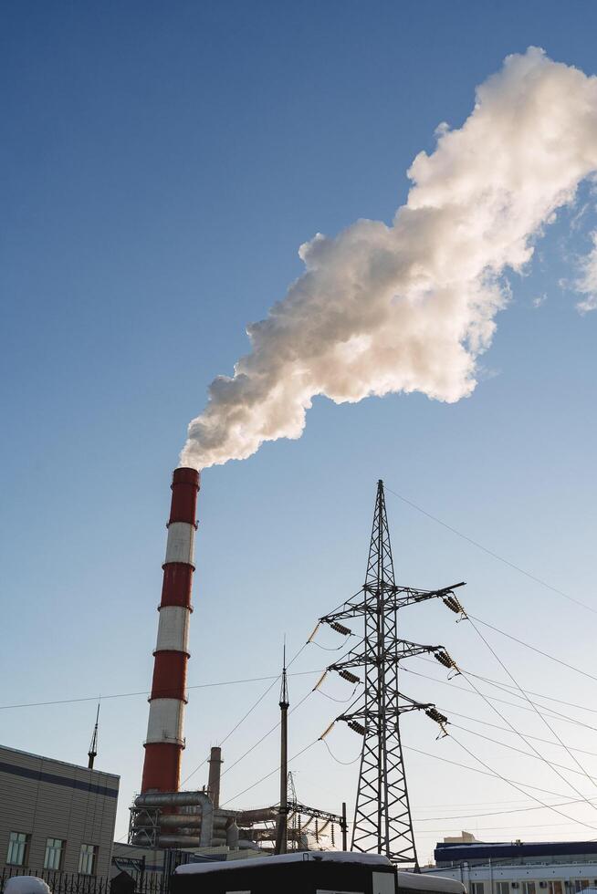 Harmful pipe production emits acrid smoke into the atmosphere polluting the air. An industrial disaster, the plant smokes poisoning the city. photo