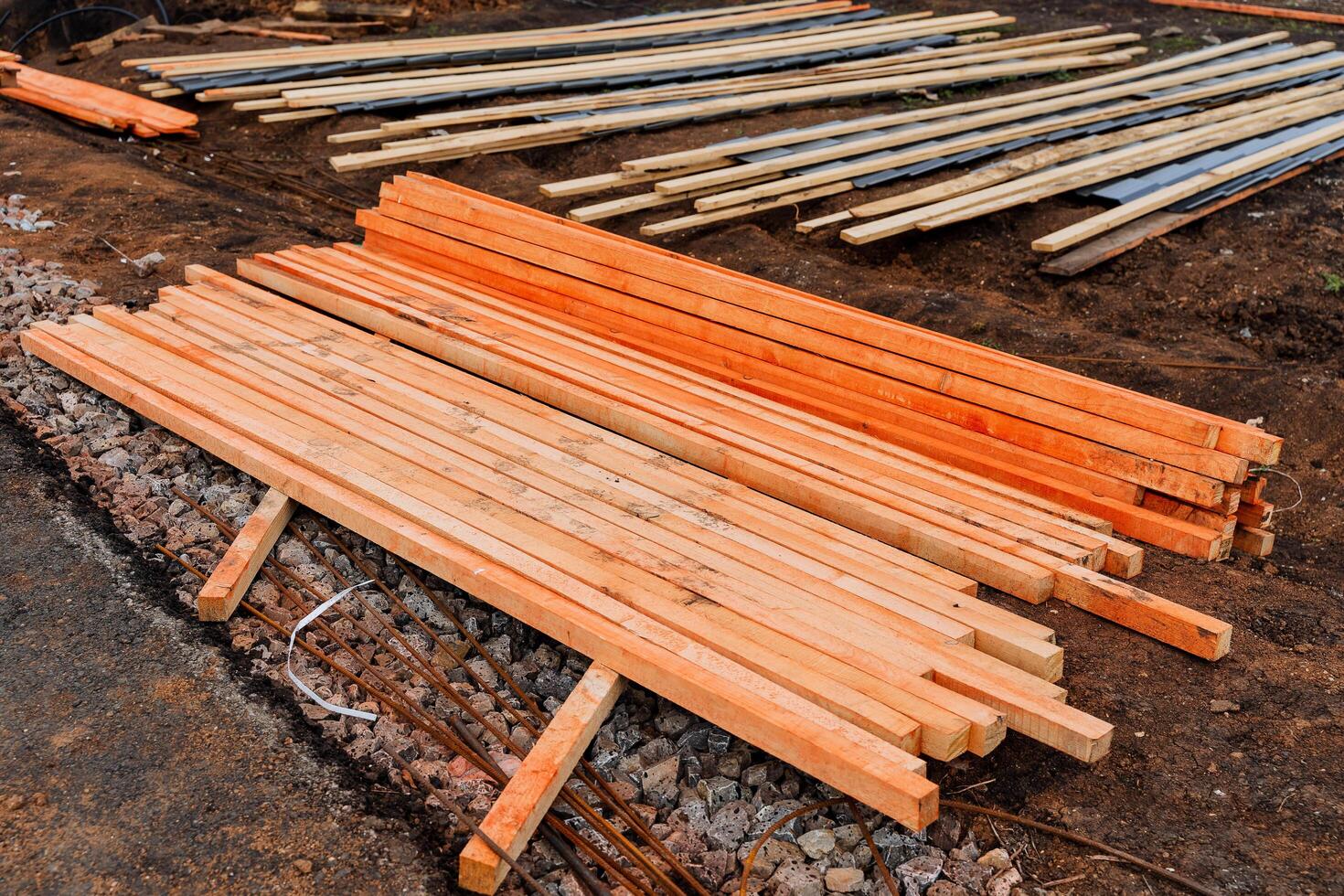 Wooden boards treated with a red protective agent, pine bars painted with paint from rotting, construction site. photo